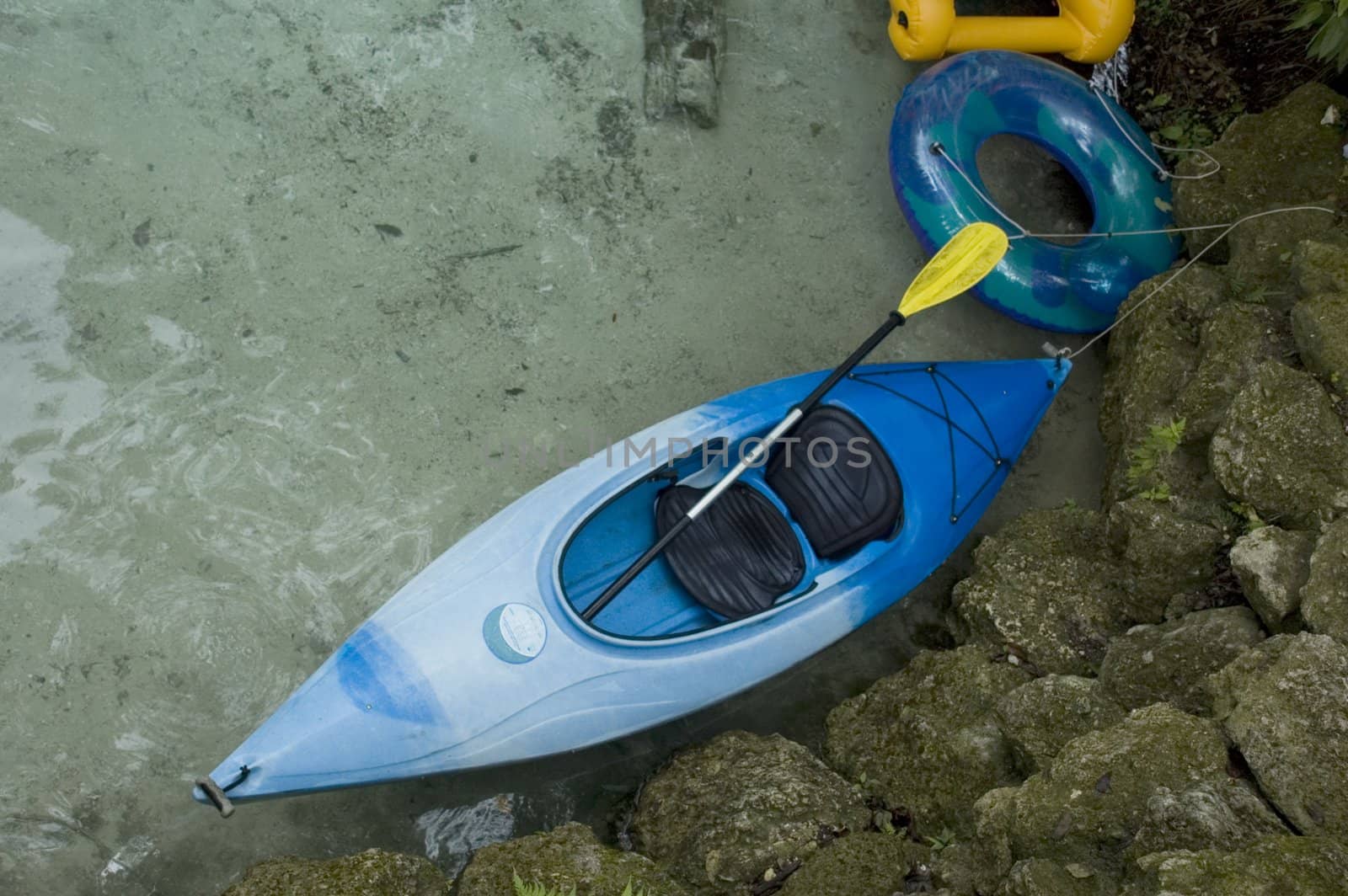 A kayak and tubes on the sandy side of a Florida spring.