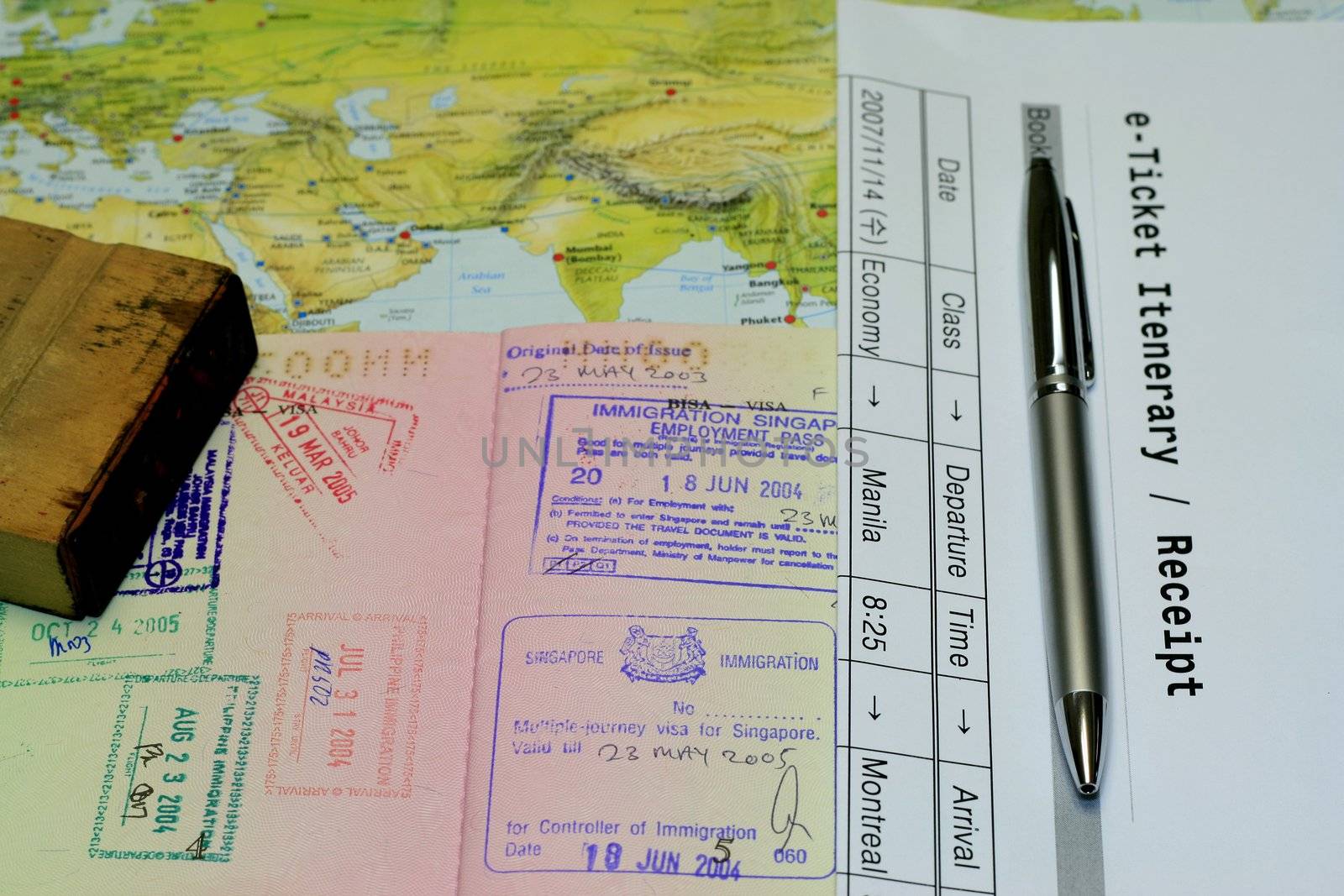 e-ticket iterenary passport and rubber stamp lain in a world map - conceptual for travel, business trip and holidays.