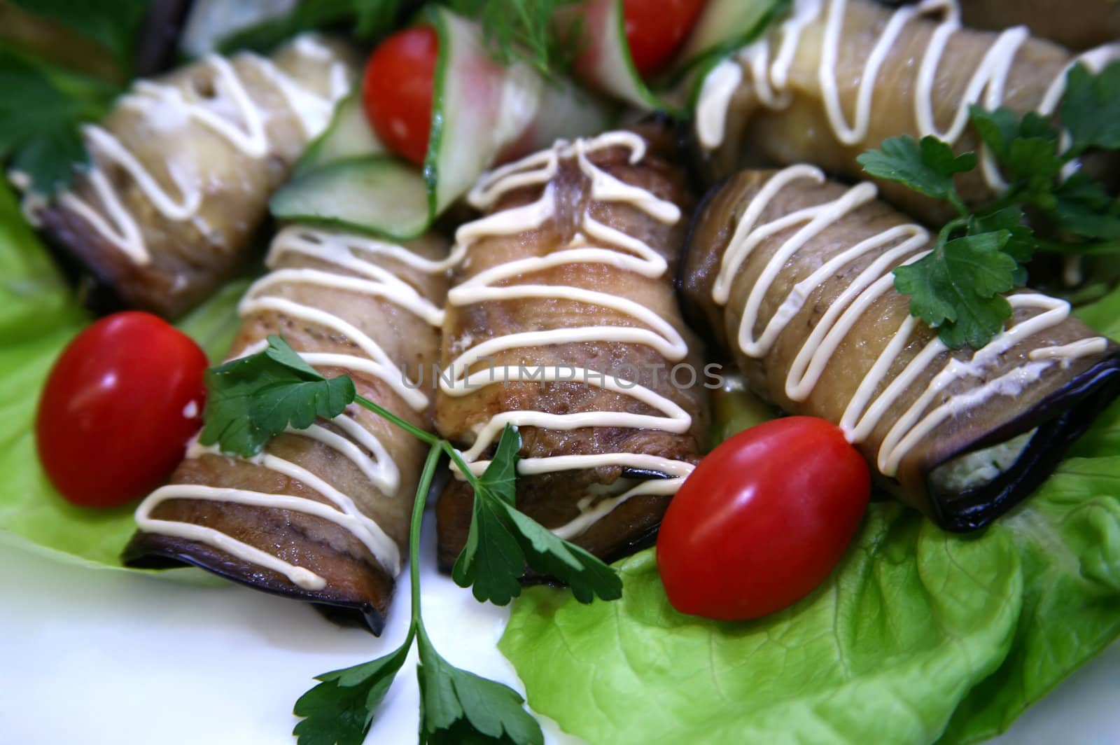 Eggplants filled by cheese and garlic on leaves of salad