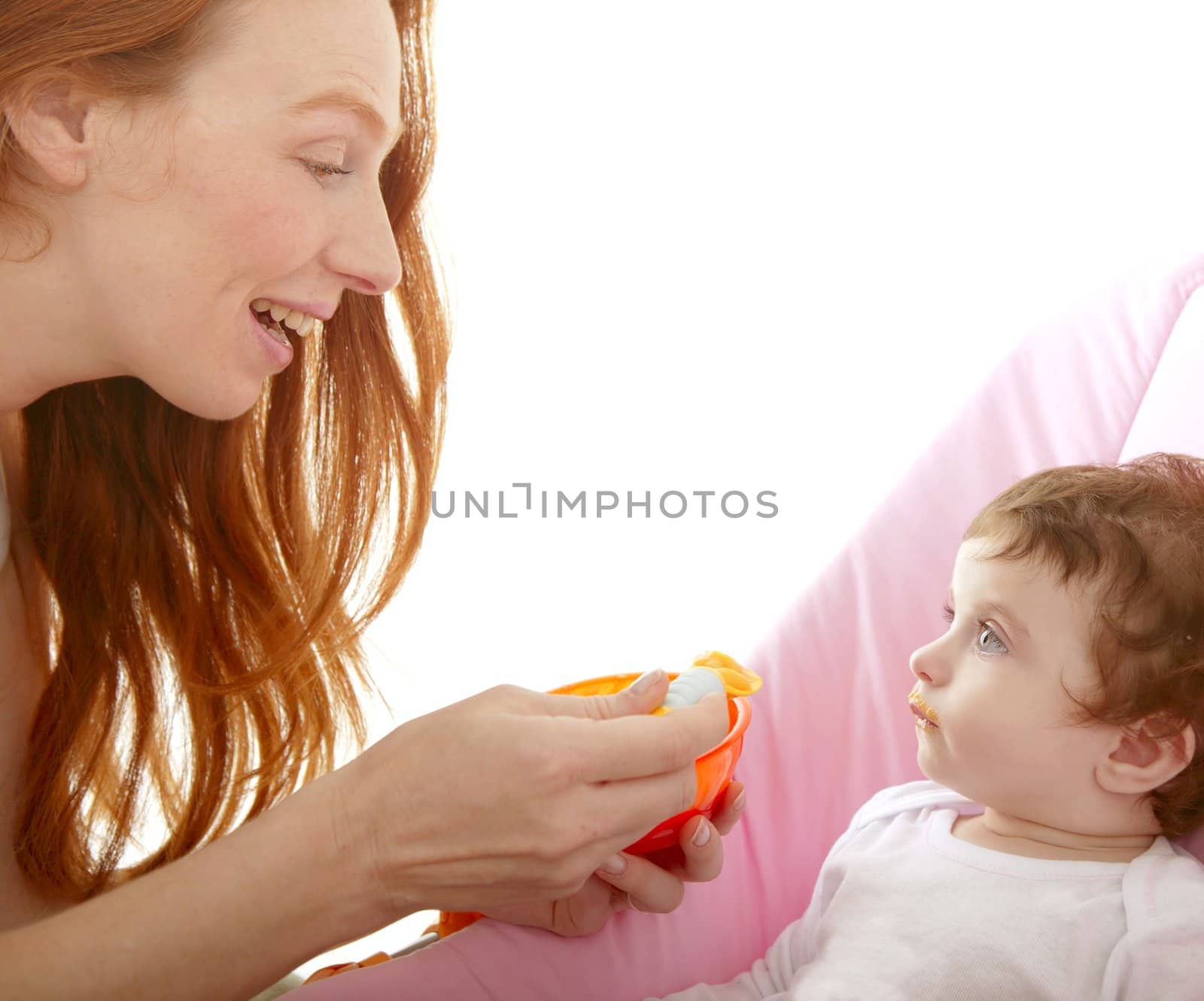 mother feeding baby yellow spoon white background