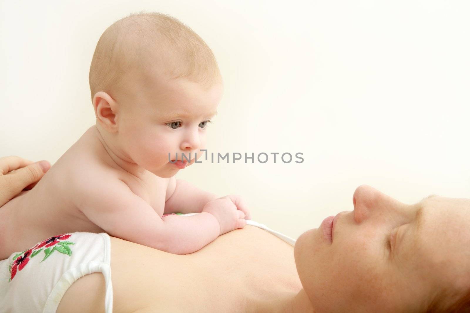 baby nude blond on mother arms white background