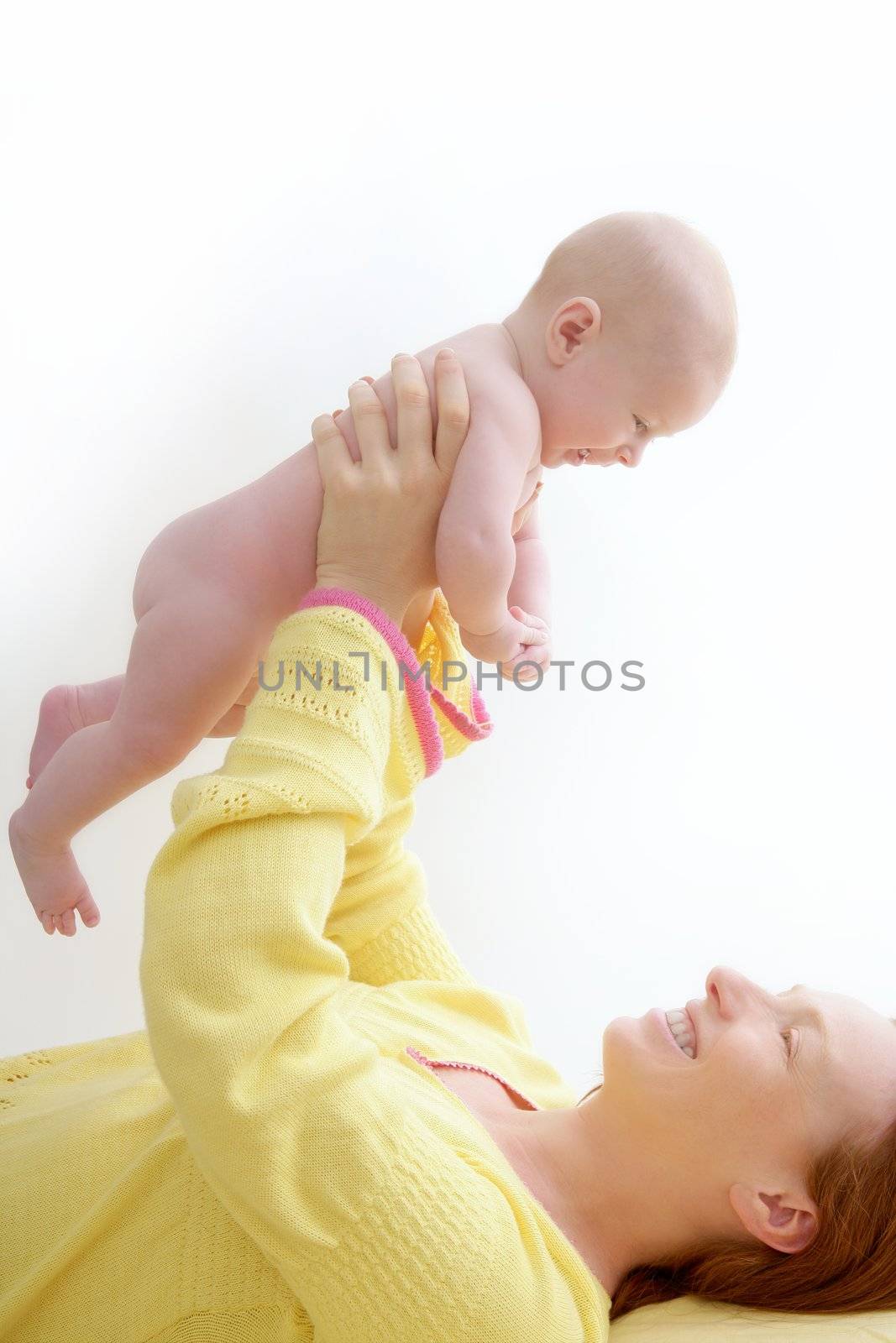 mother holding nude baby playing white background