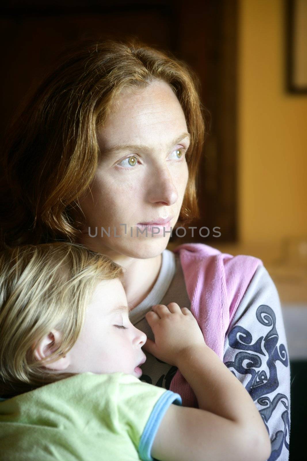 Baby toddler girl sleeping in redhead mother arms tranquil scene