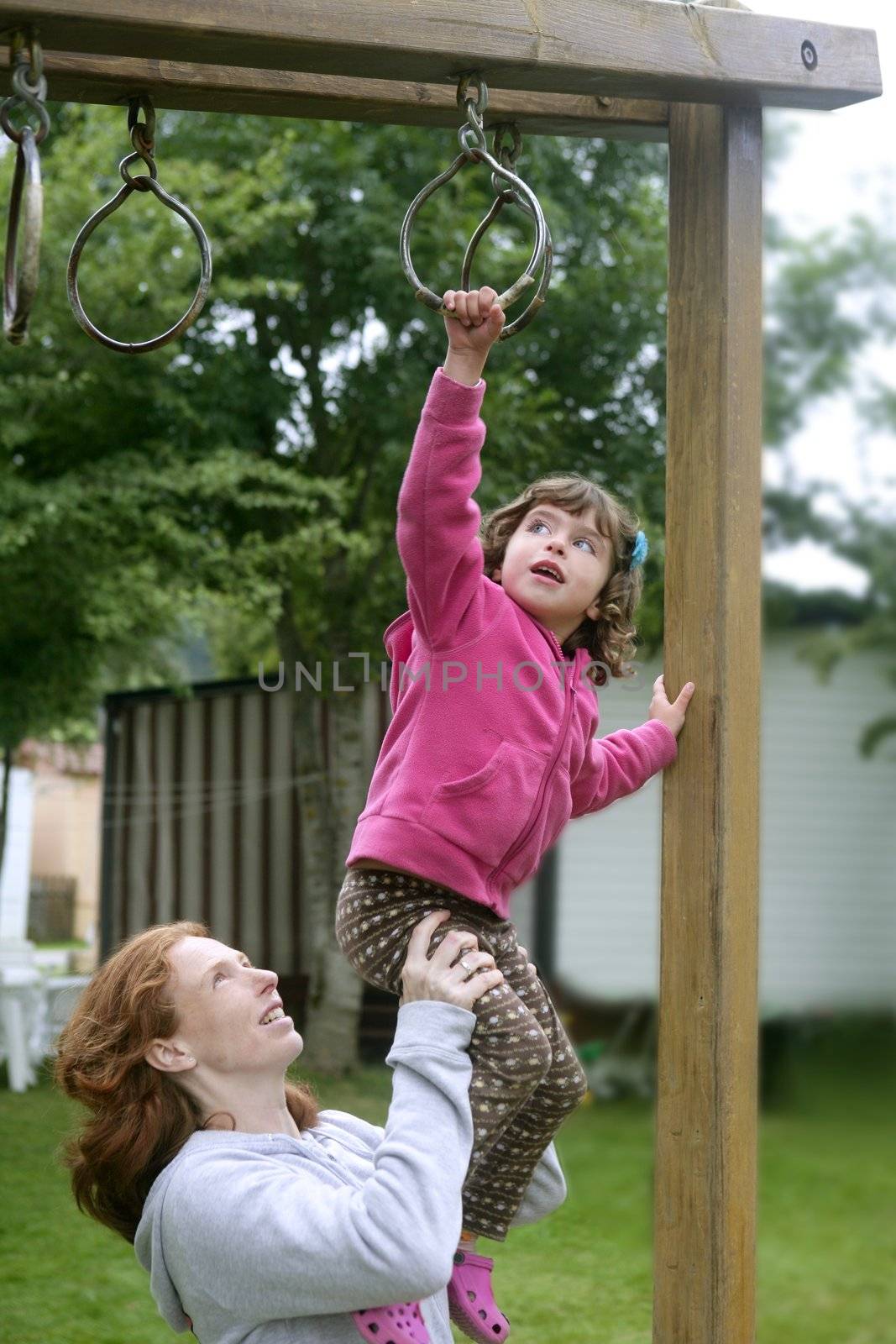 Daughter and mother playing on the wooden playground