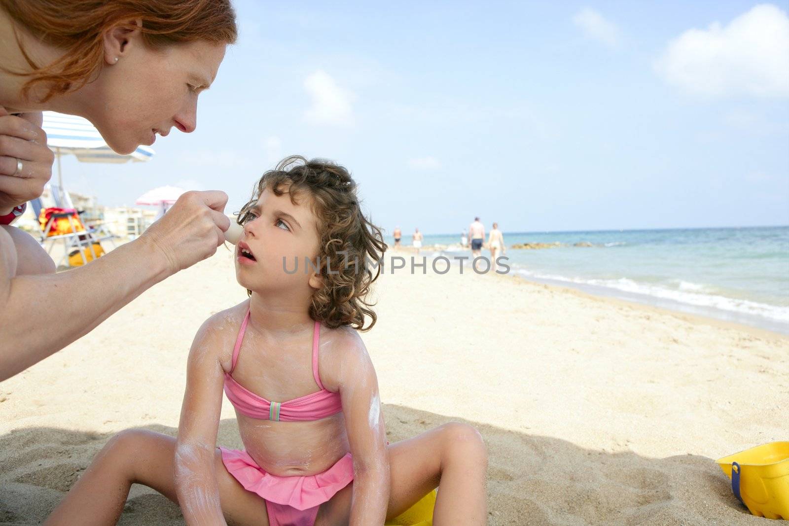 Daughter and mother on the beach sun screen protection moisture cream