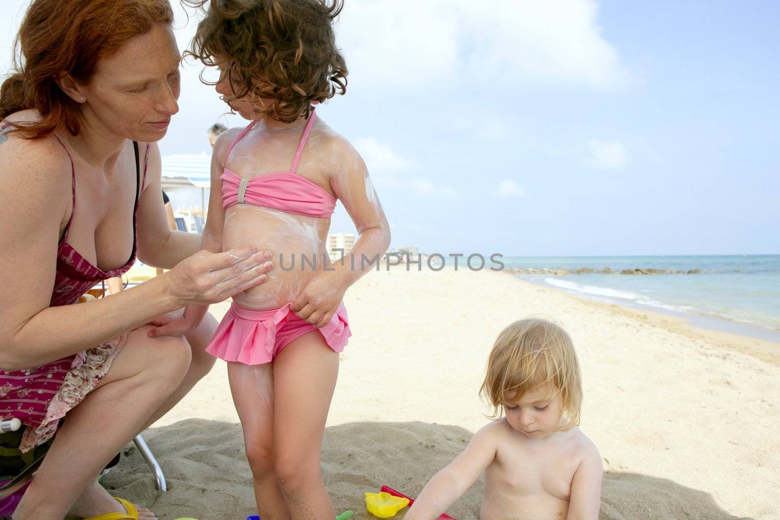 Daughter and mother on the beach sun screen protection moisture cream