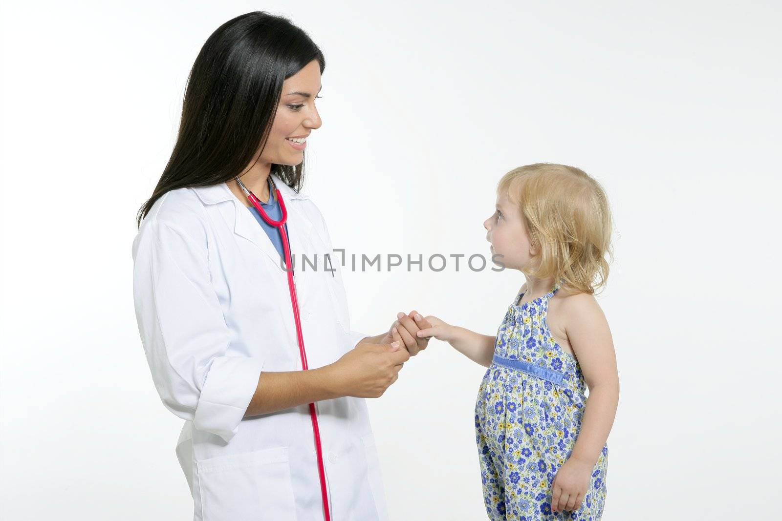 Brunette pediatric doctor with blond little girl on medical exam