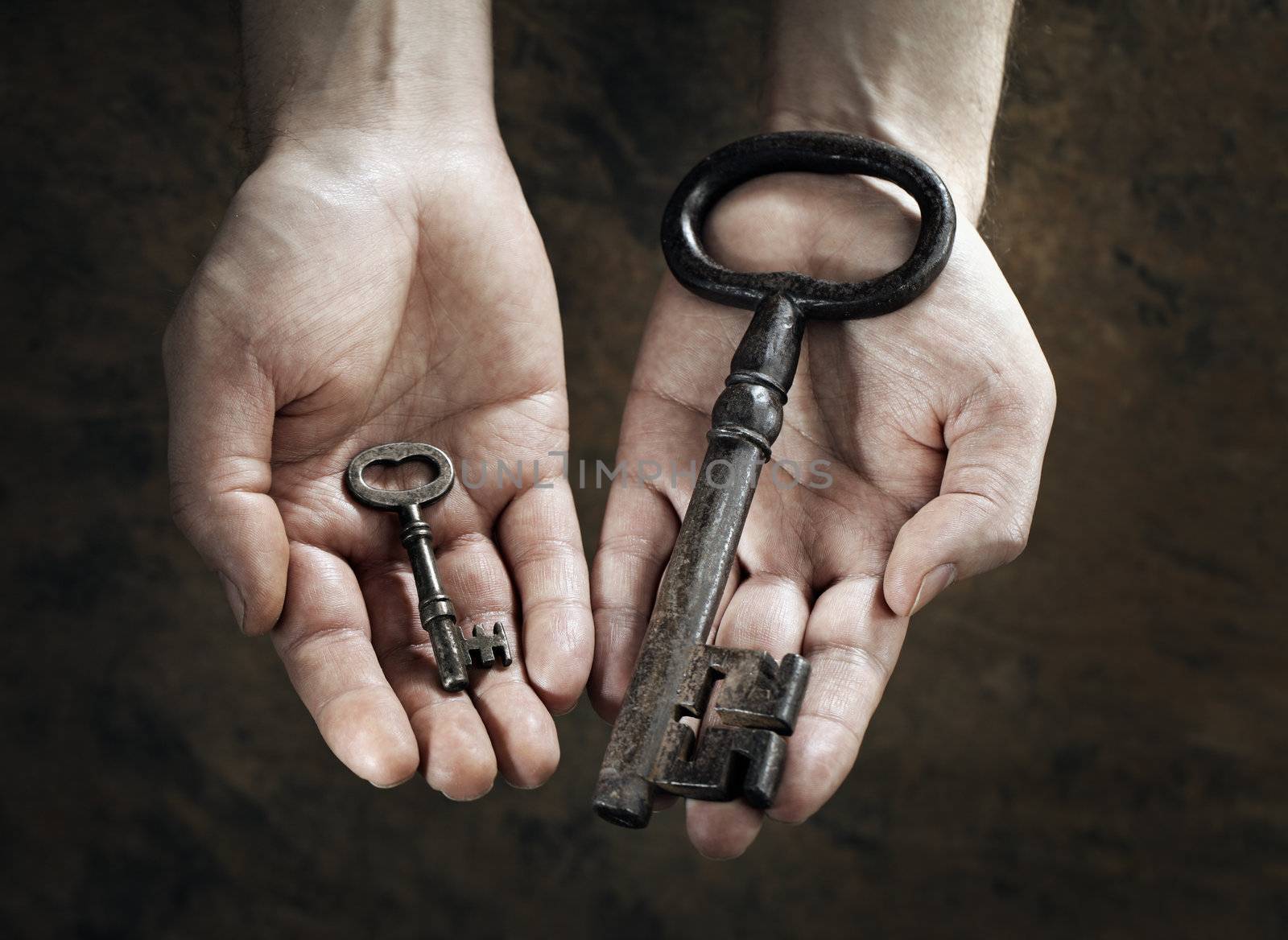 Man holding a big and a small key in his hands.