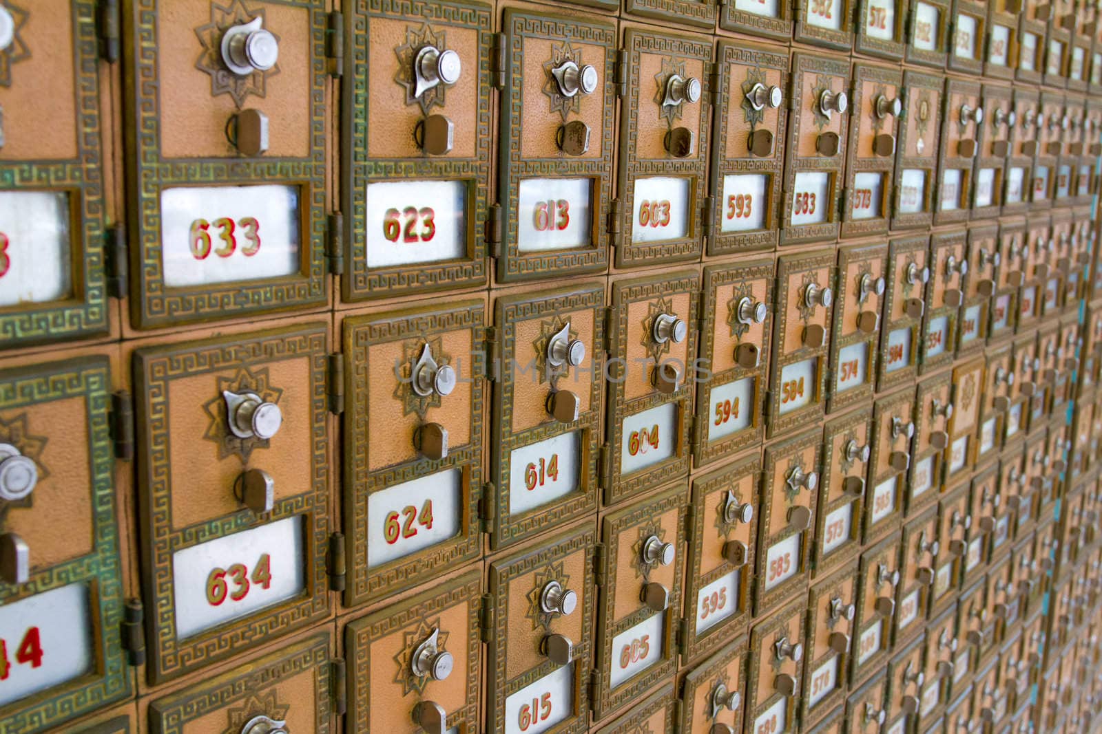 This photo shows the many po boxes at the post office. The mail boxes are lined up in rows and columns for organization.