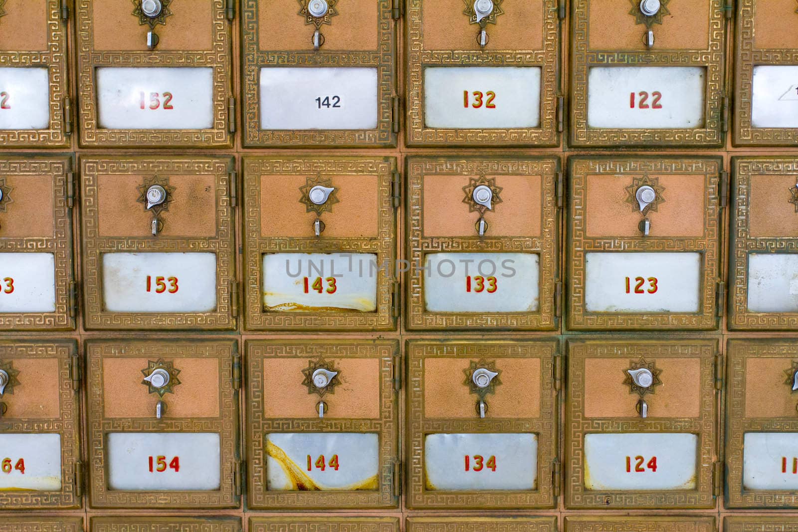 This photo shows the many po boxes at the post office. The mail boxes are lined up in rows and columns for organization.