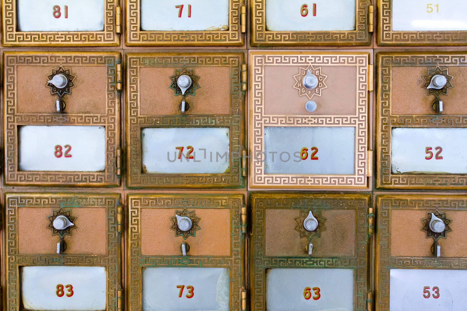 This p.o. box (or post office mail box) has been replaced and is shiny compared to the surrounding boxes. It has the number 62.