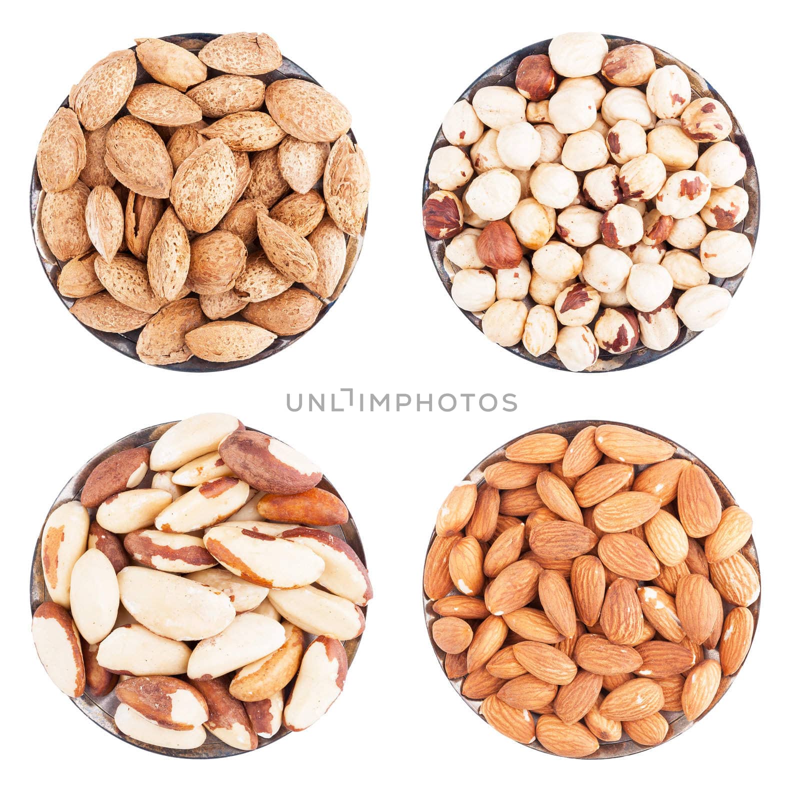 Assorted nuts on a flat plate, isolated on white