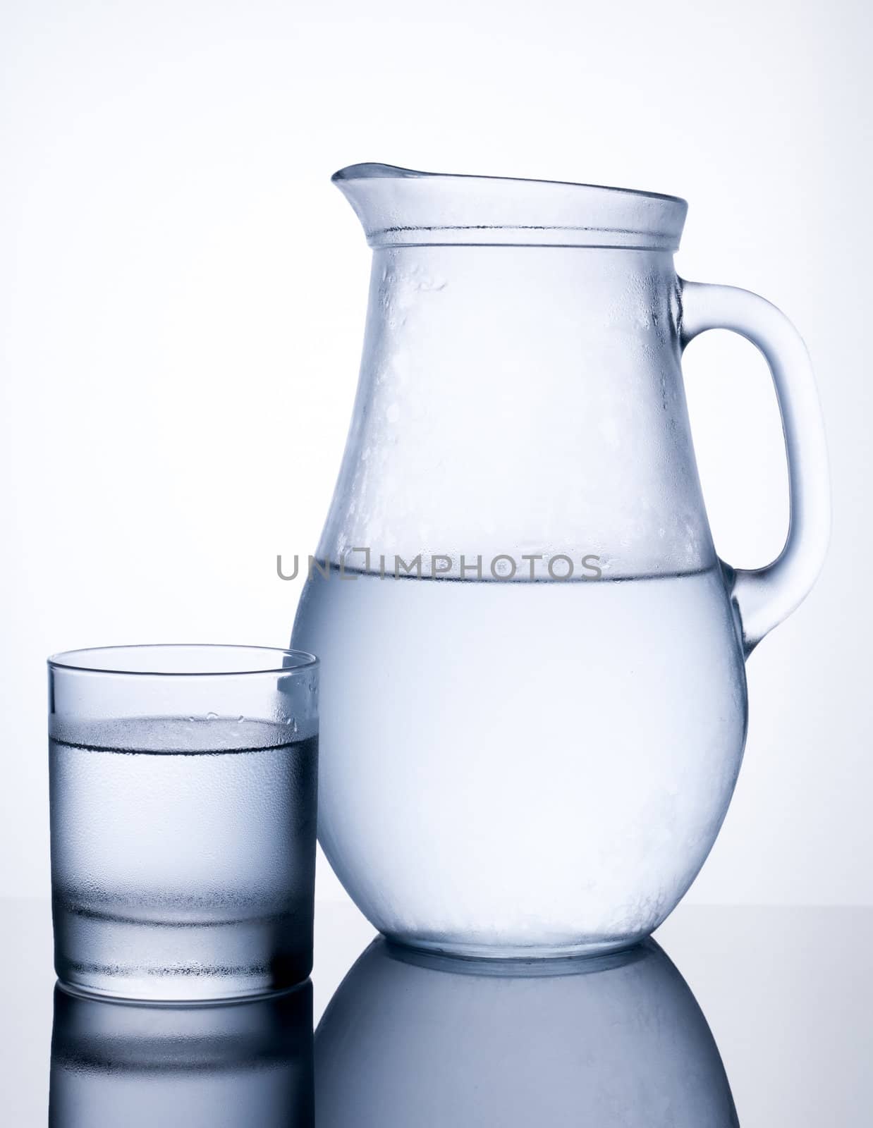 Pitcher of clear cold water with glass isolated on white background