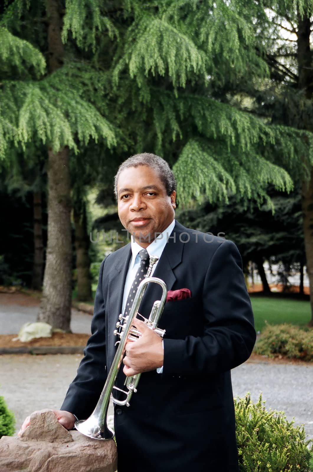 Jazz trumpet with his instrument outdoors.