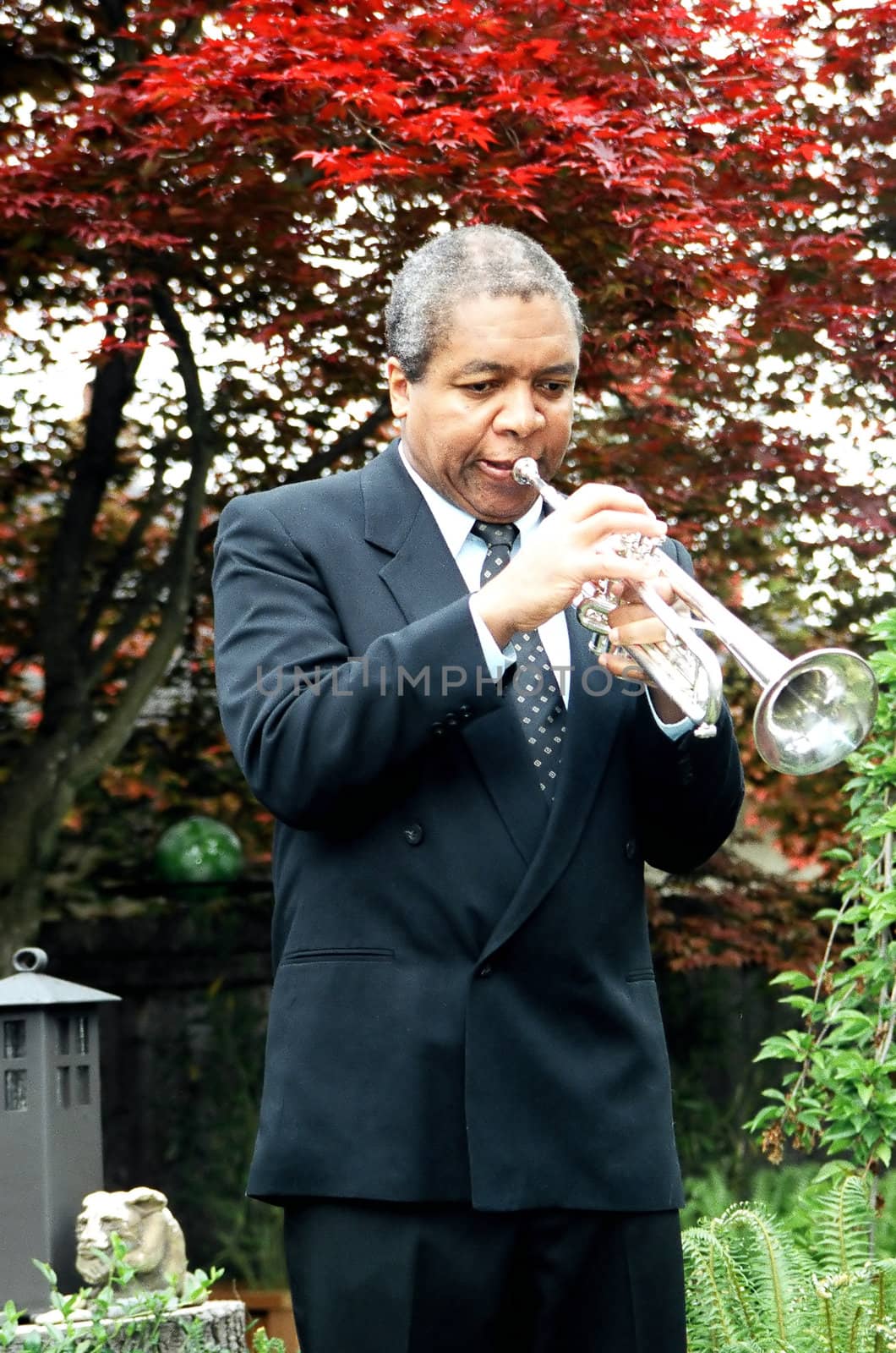 Jazz trumpet with his instrument outdoors.