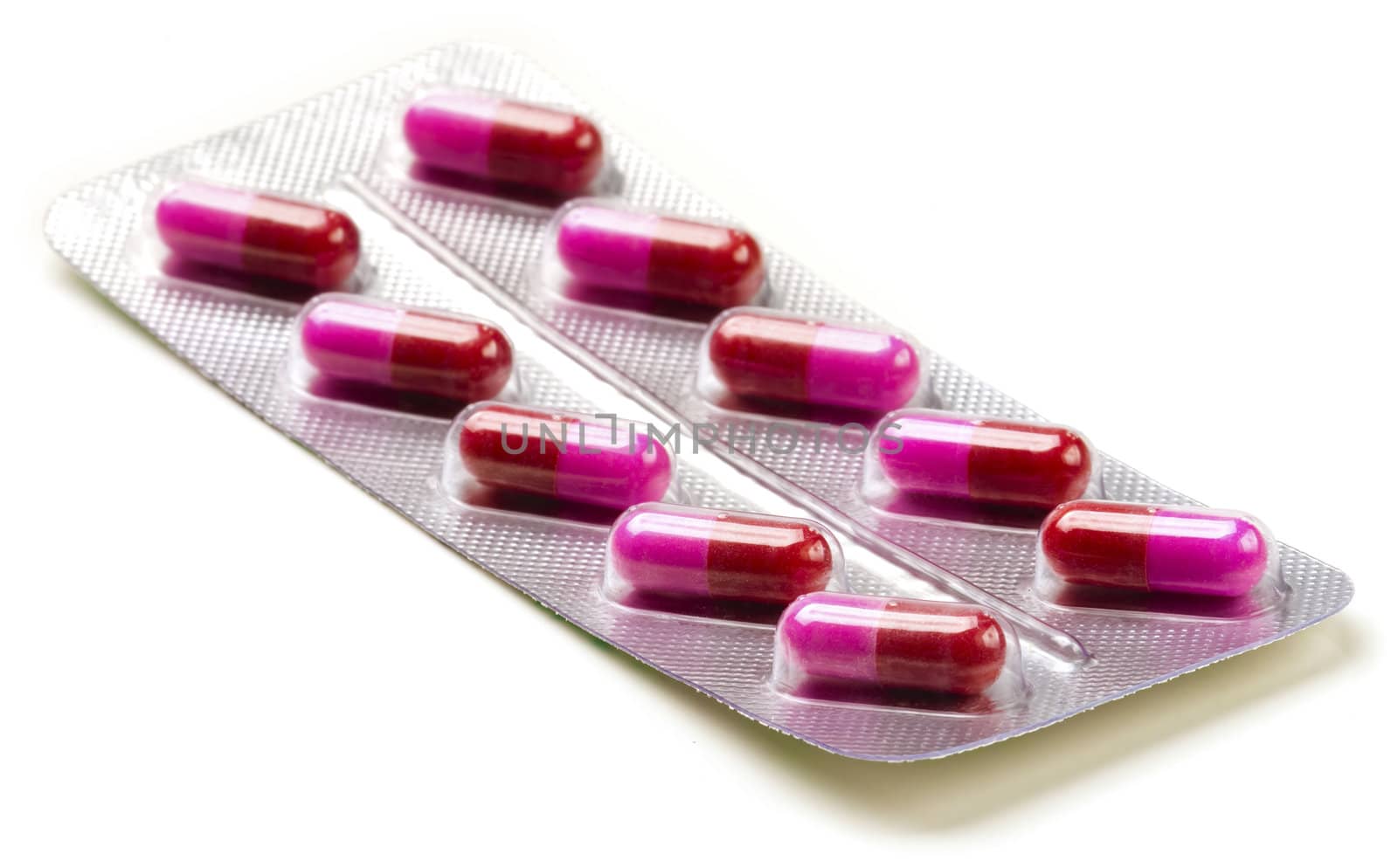 Pack of medical red and pink capsules on white.