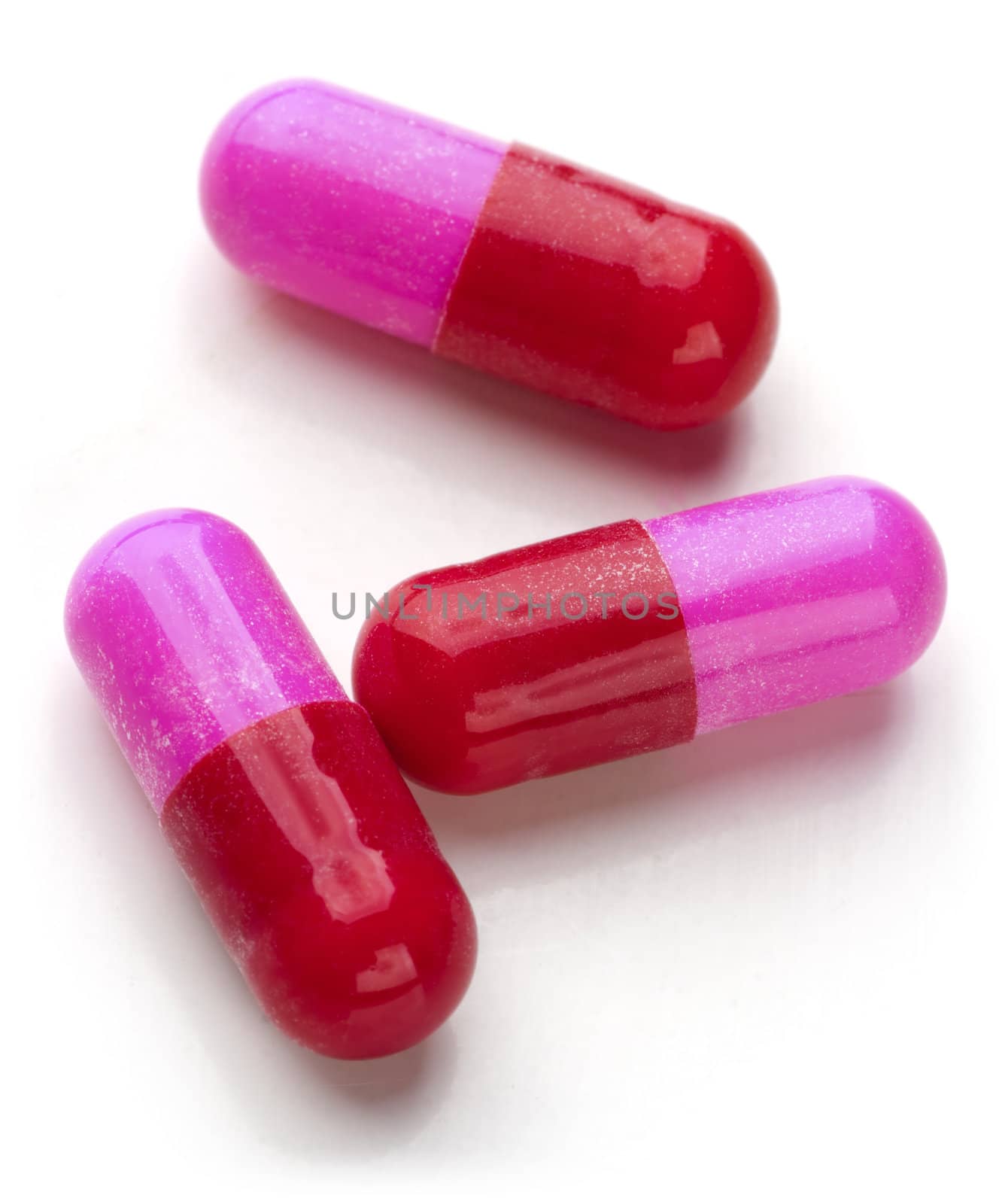 Bunch of red and pink capsules on white background. 







Bunch of red and pink capsules on white background.