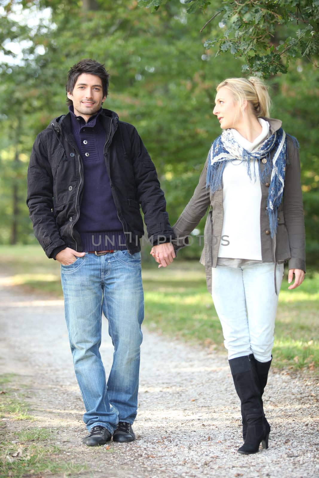 couple walking in the park hand in hand by phovoir