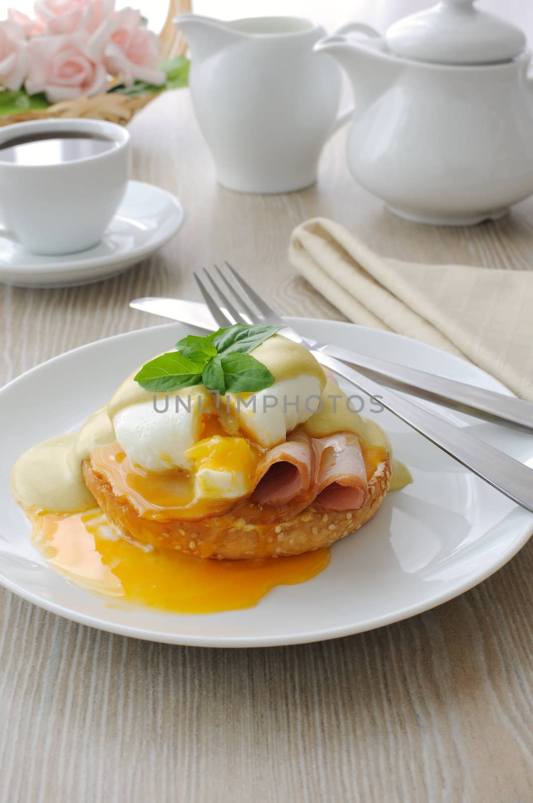 Breakfast of boiled eggs (poached) with ham on a bun with mustard sauce