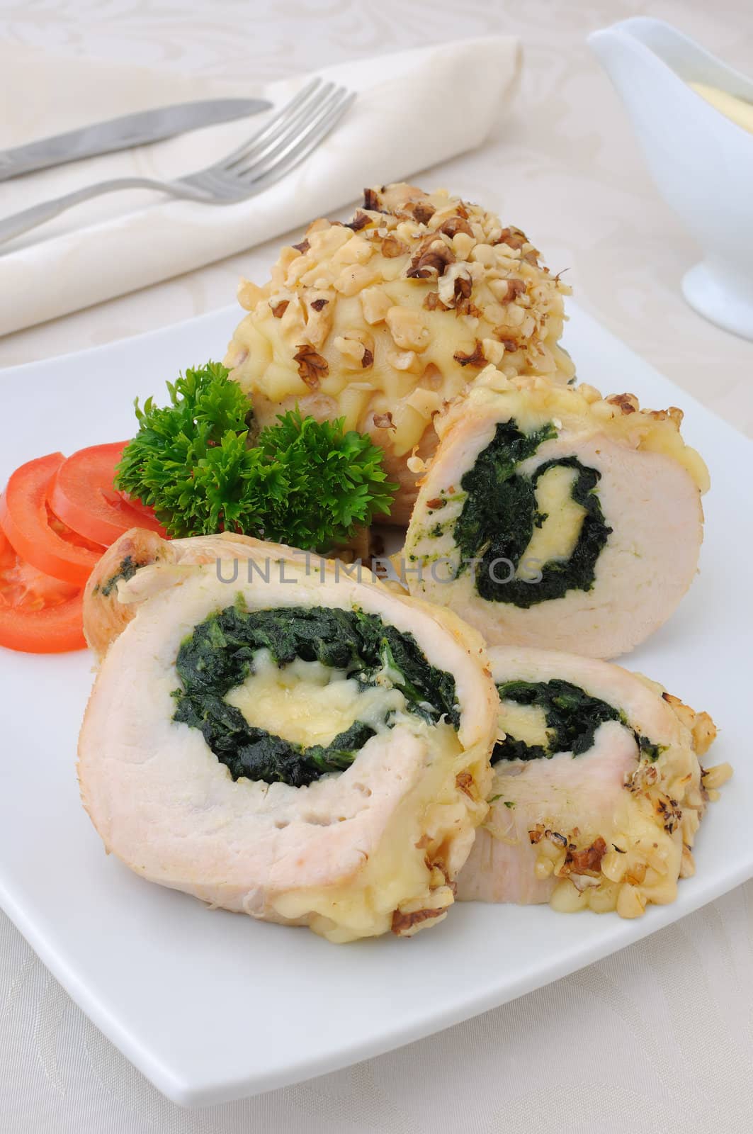 Sliced chicken roll stuffed with spinach and mozzarella and cheese with walnuts