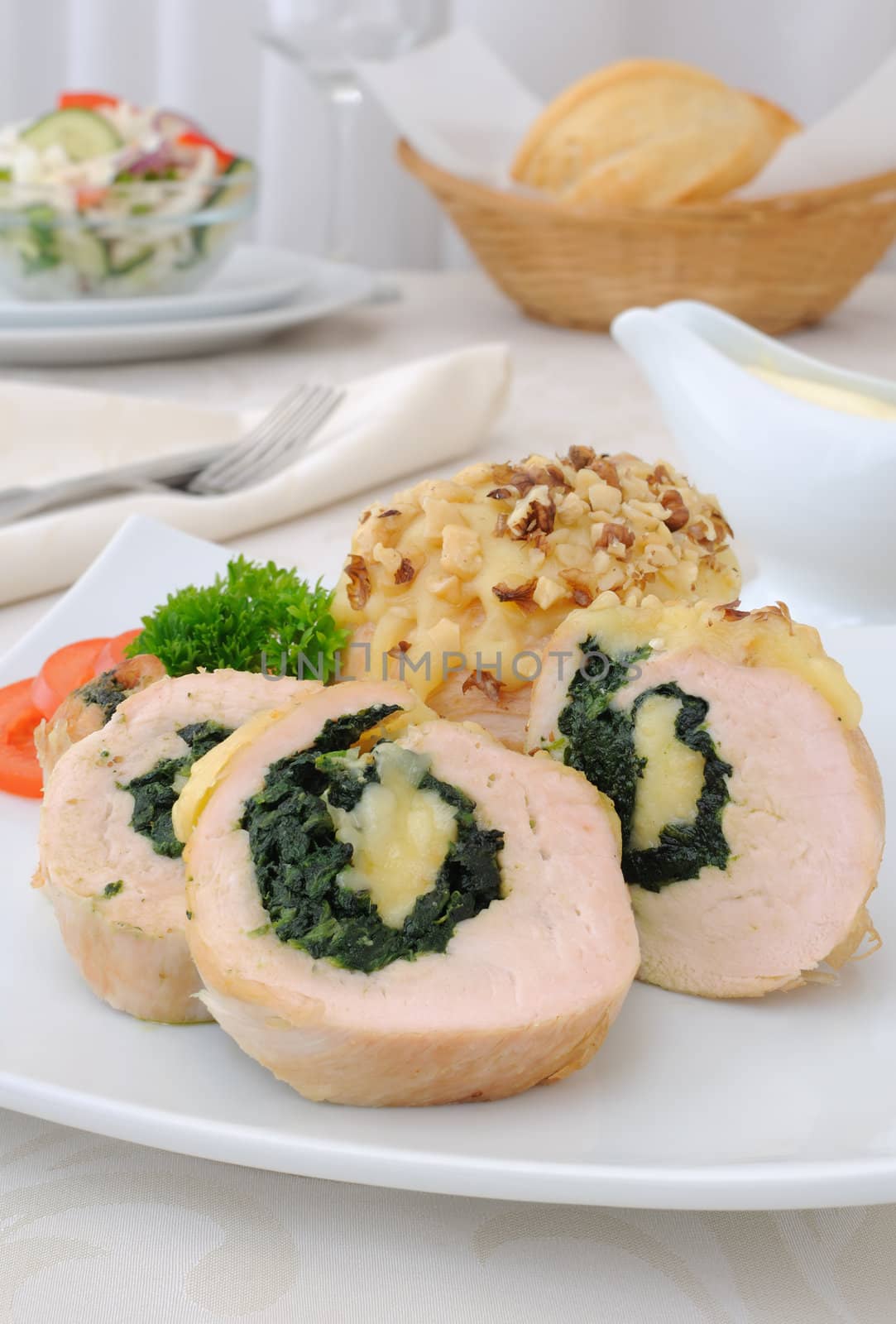 Sliced chicken roll stuffed with spinach and mozzarella and cheese with walnuts