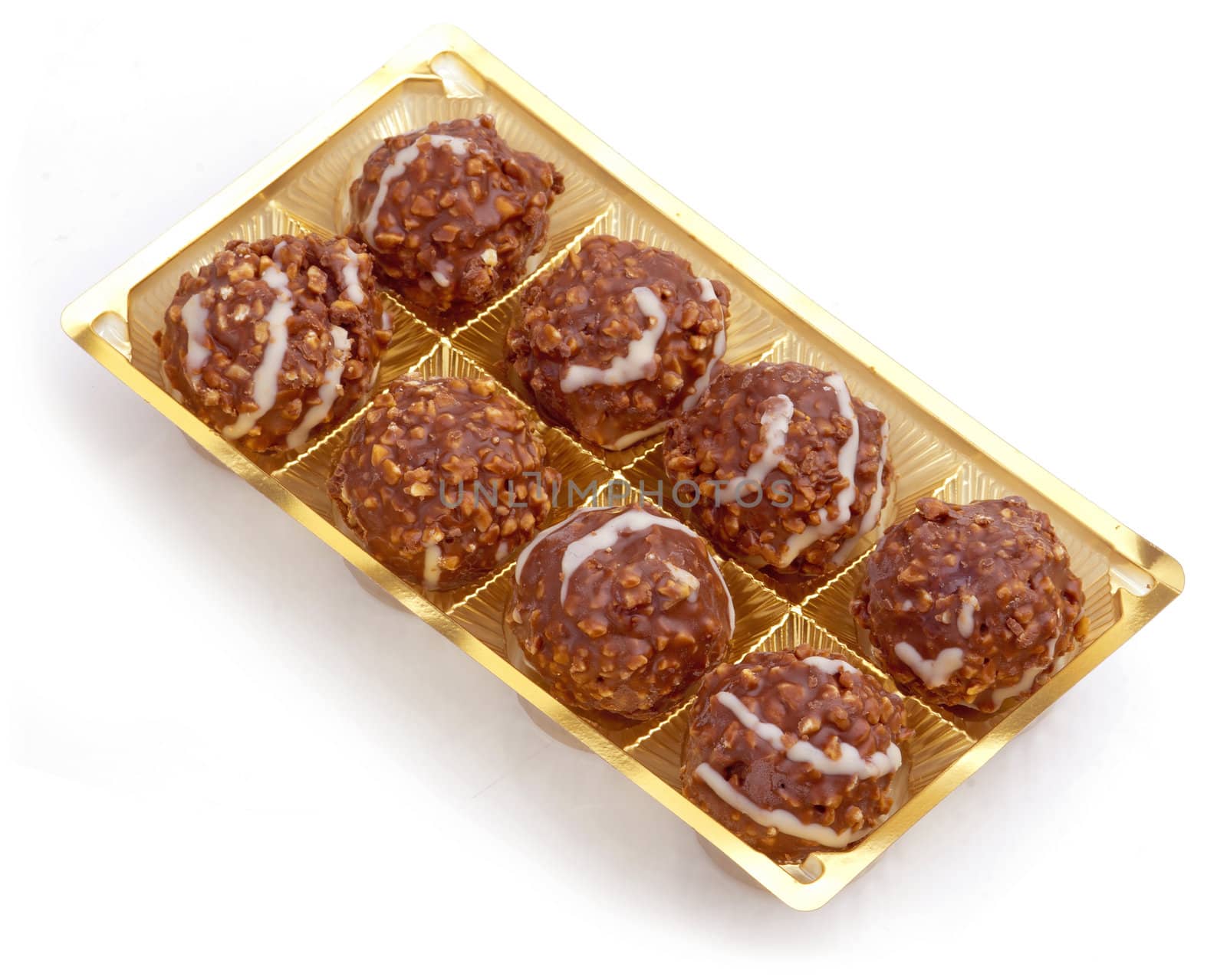 Sweet chocolate balls filled with hazelnuts in plastic package on a white background.







Sweet chocolate balls filled with hazelnuts in plastic package on a white background.