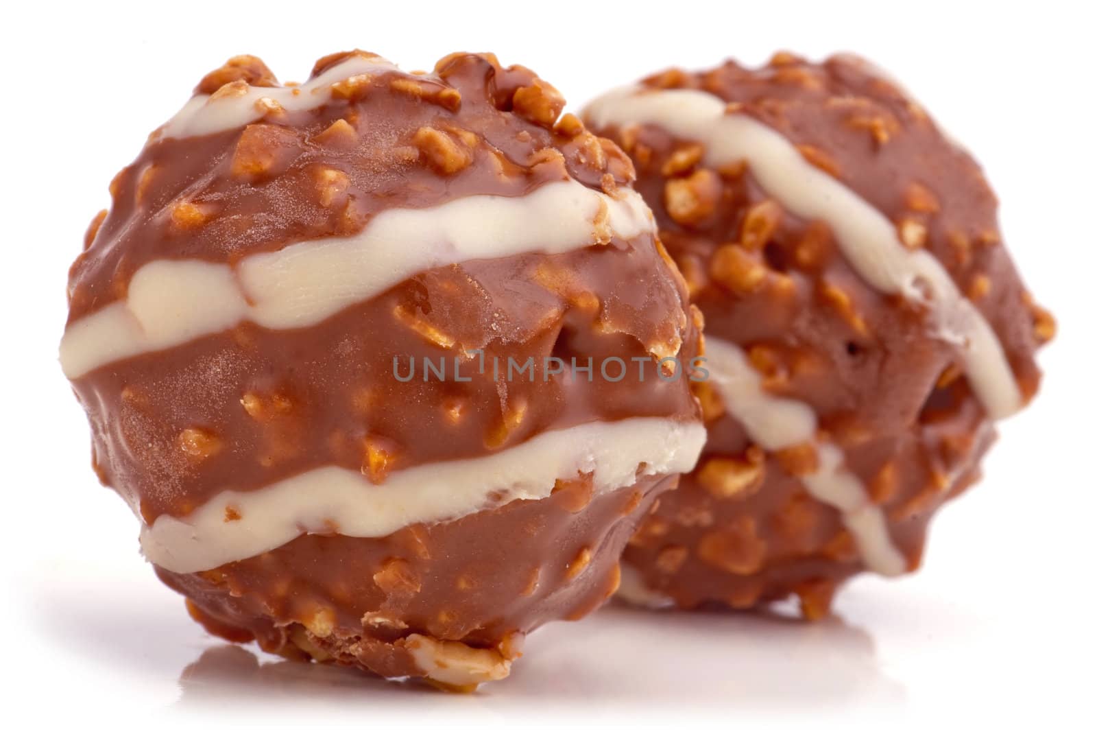 Sweet chocolate balls filled with hazelnuts on a white background.