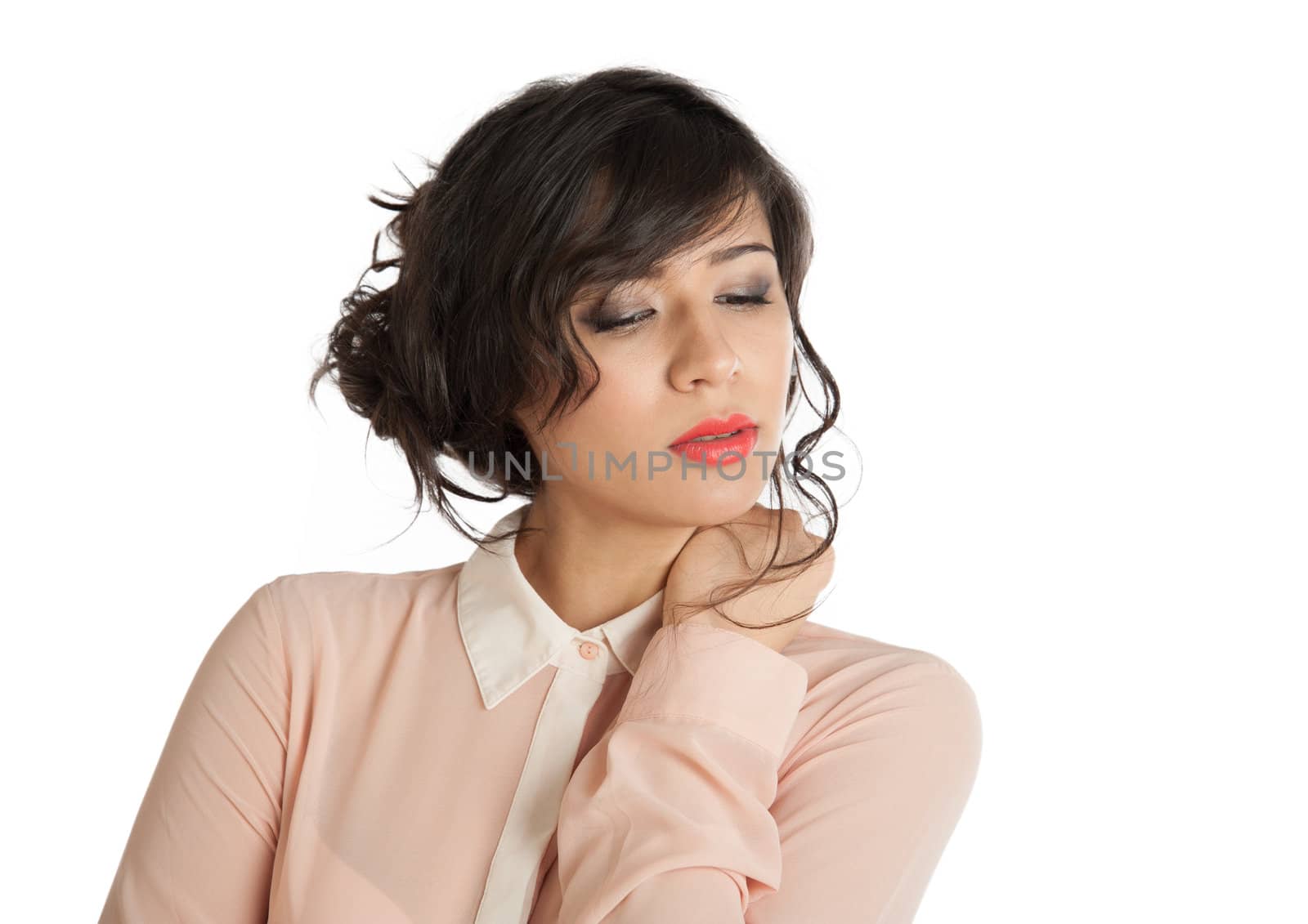 Brunette in a pink blouse looks down on a white background