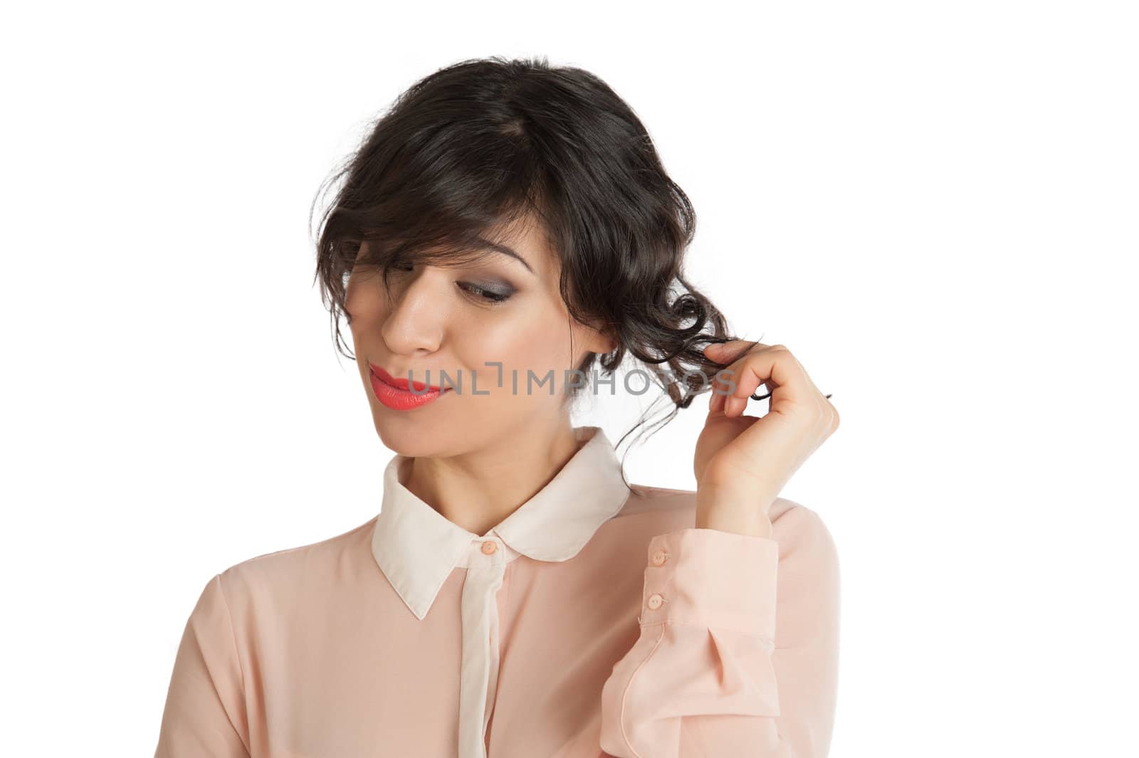 A woman in a pink blouse holds hands hair.