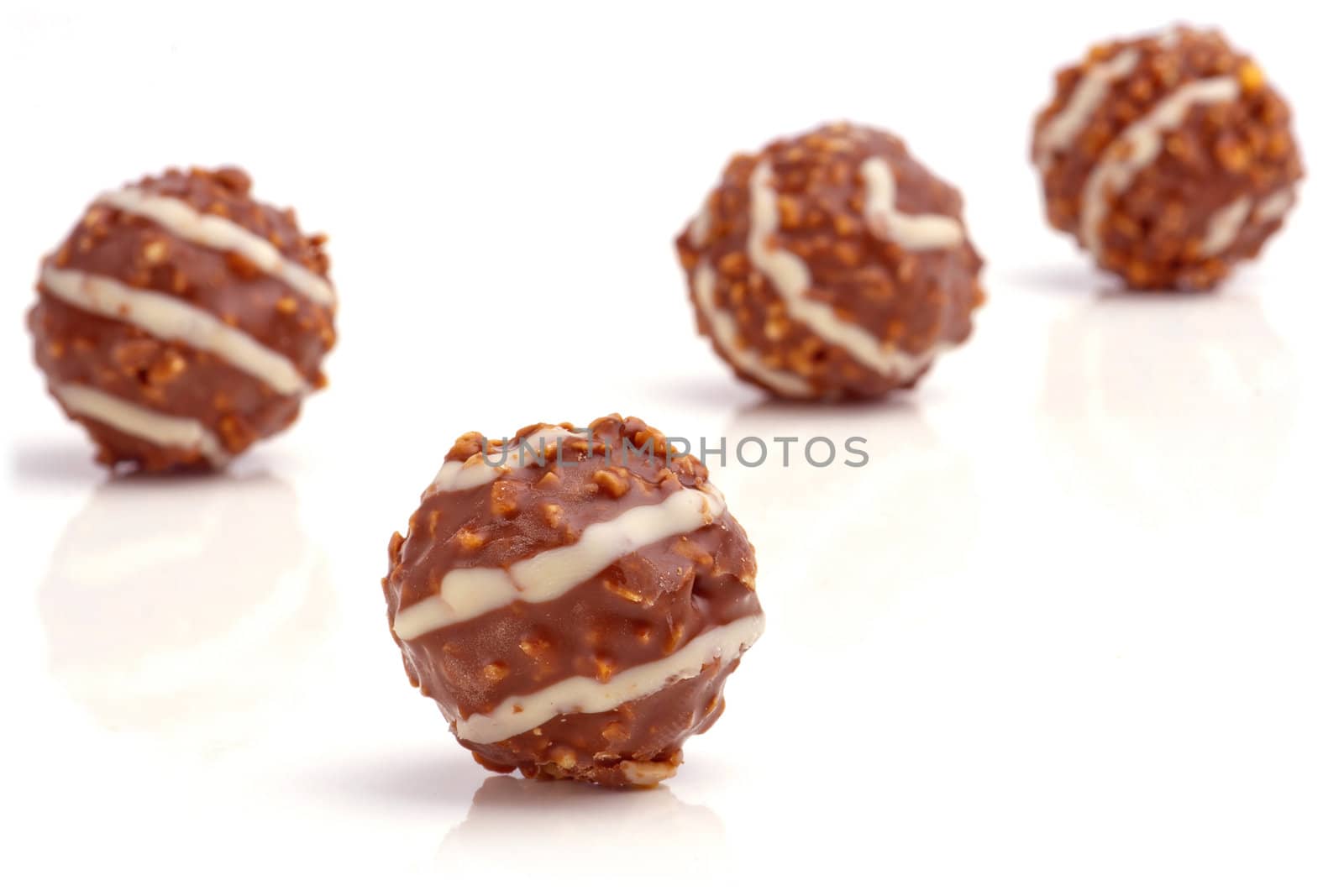 Sweet chocolate balls filled with hazelnuts on a white background.