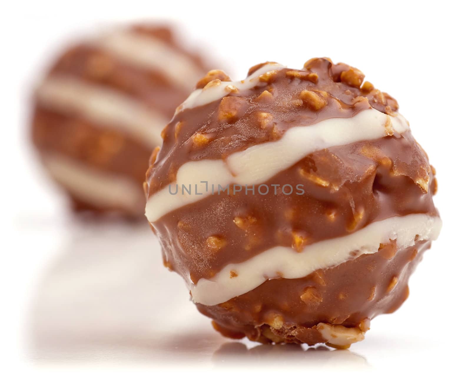 Sweet chocolate balls filled with hazelnuts on a white background.