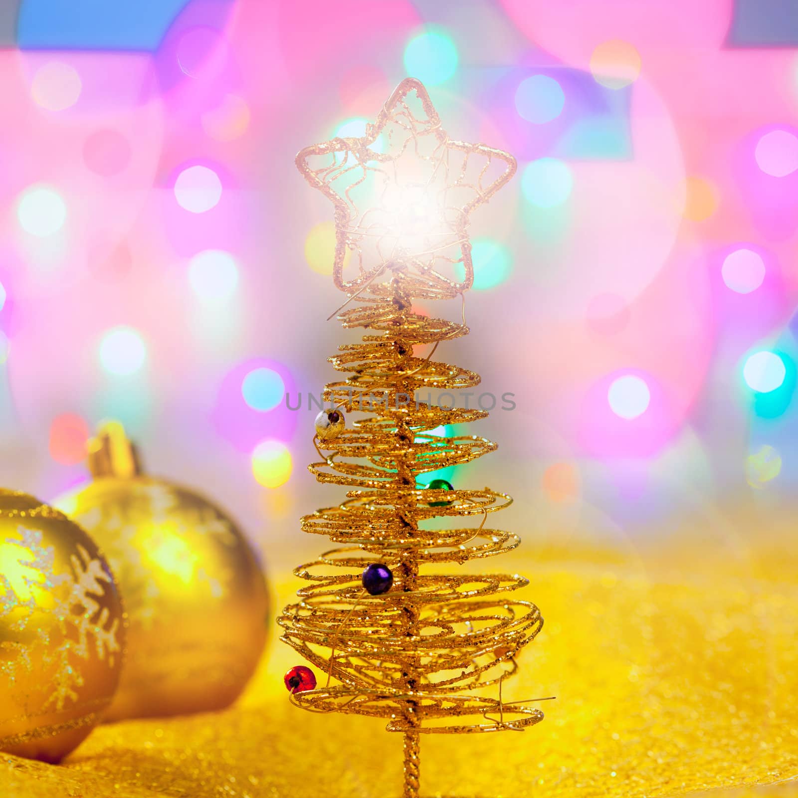 Christmas golden tree with baubles in blur lights background