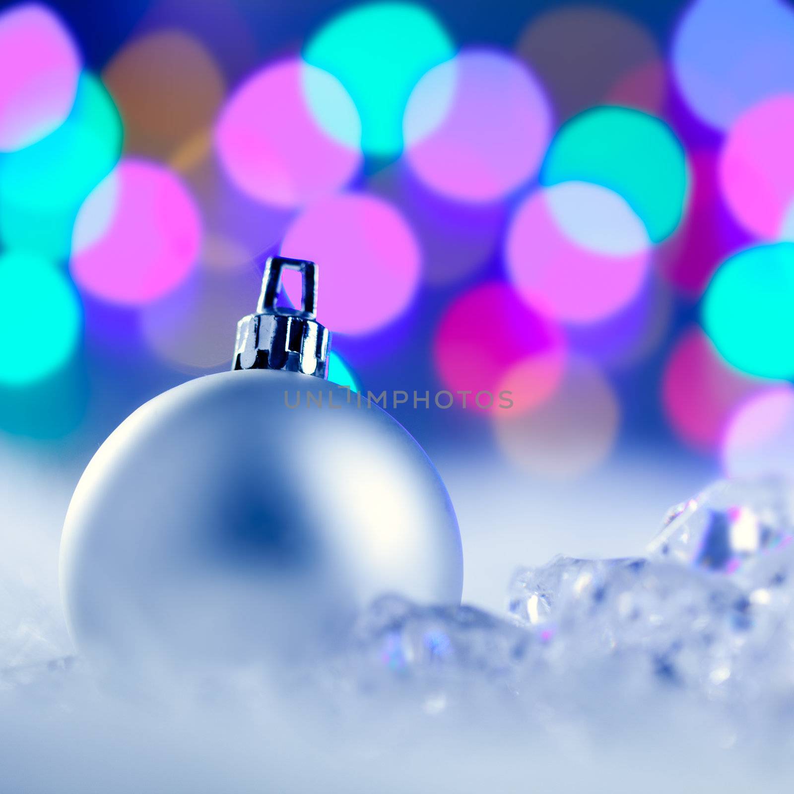 Christmas silver bauble in colorful blurred lights background