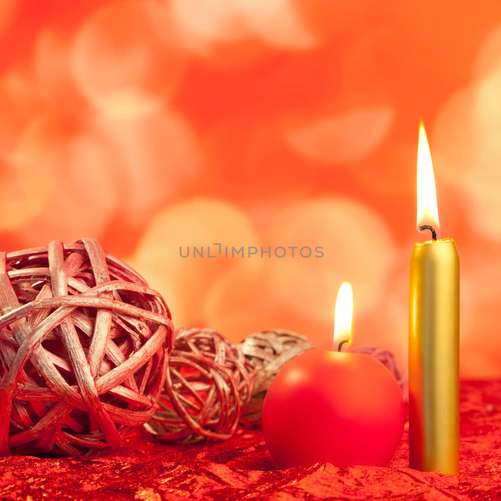 christmas candles with dried baubles on red lights background