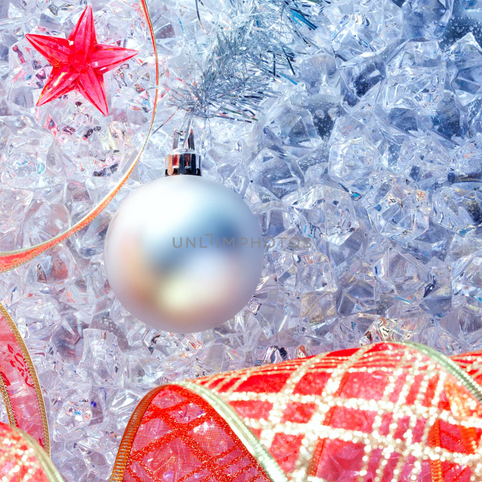 christmas silver bauble and red ribbon on ice with red star