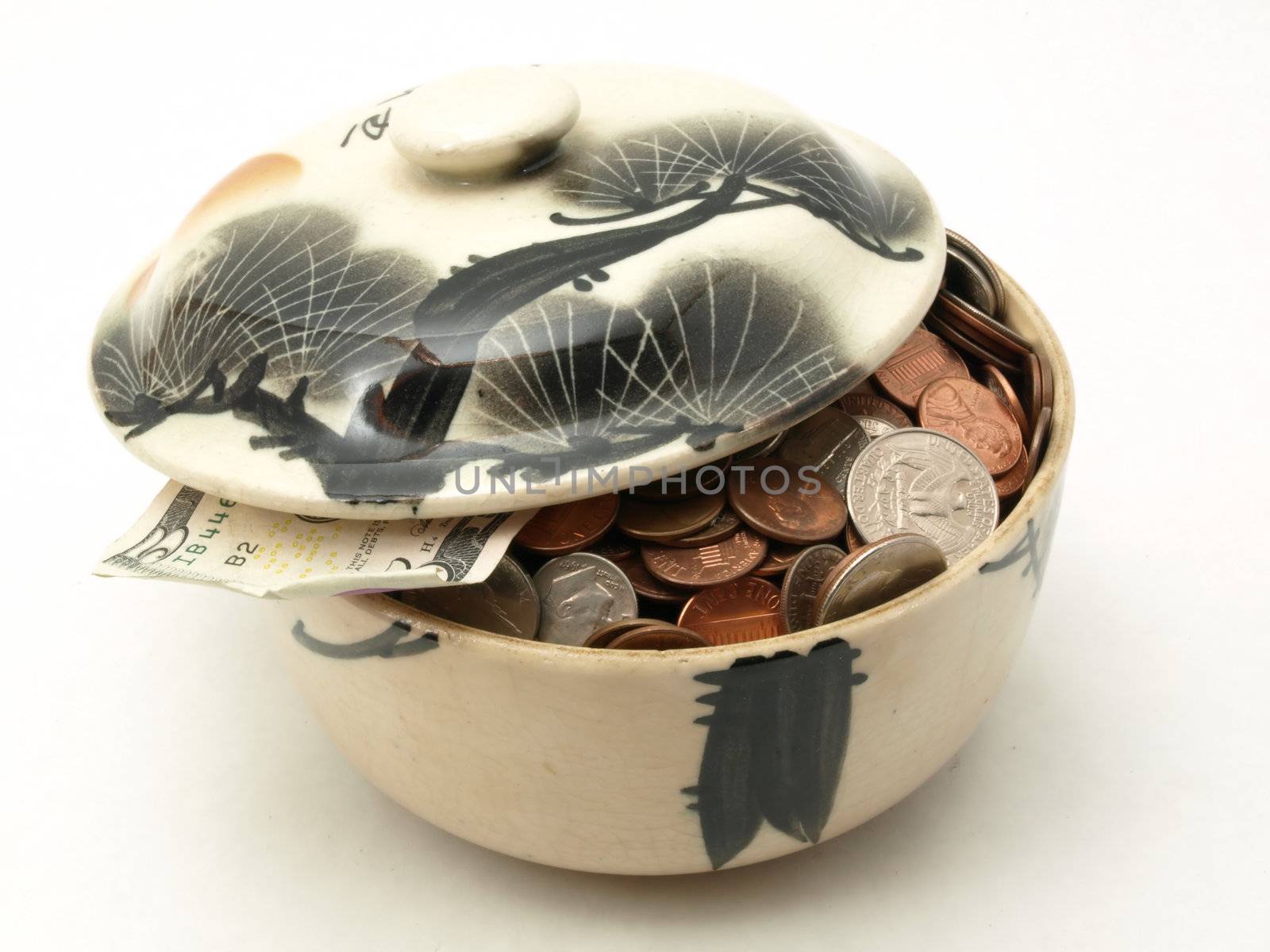 A small covered bowl full of US coins isolated on a white background.