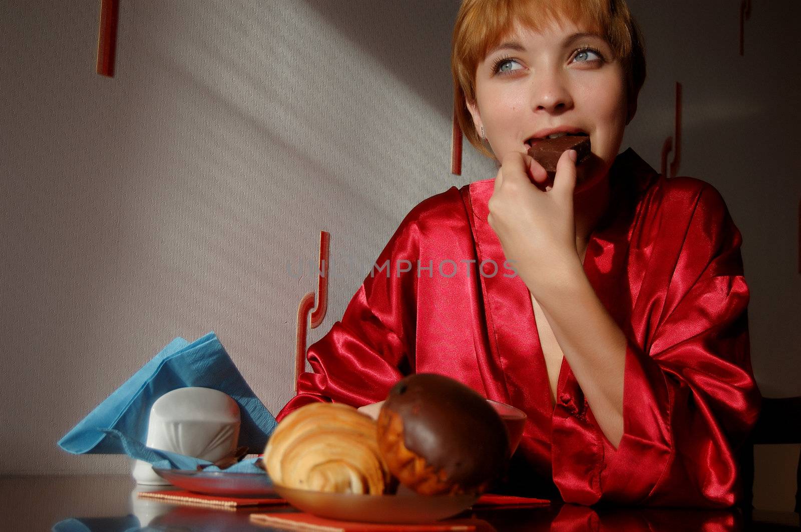 girl having breakfast with cup of tea and sweets