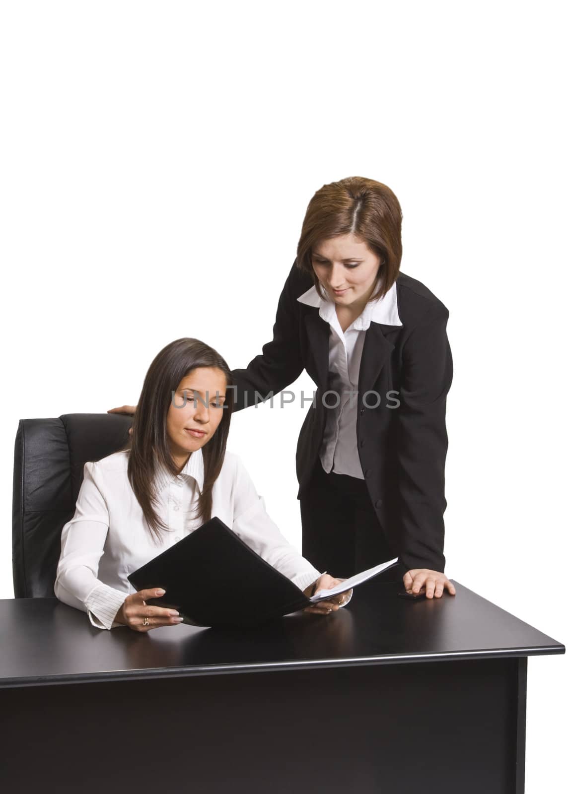 Two businesswomen reading a file in the office.