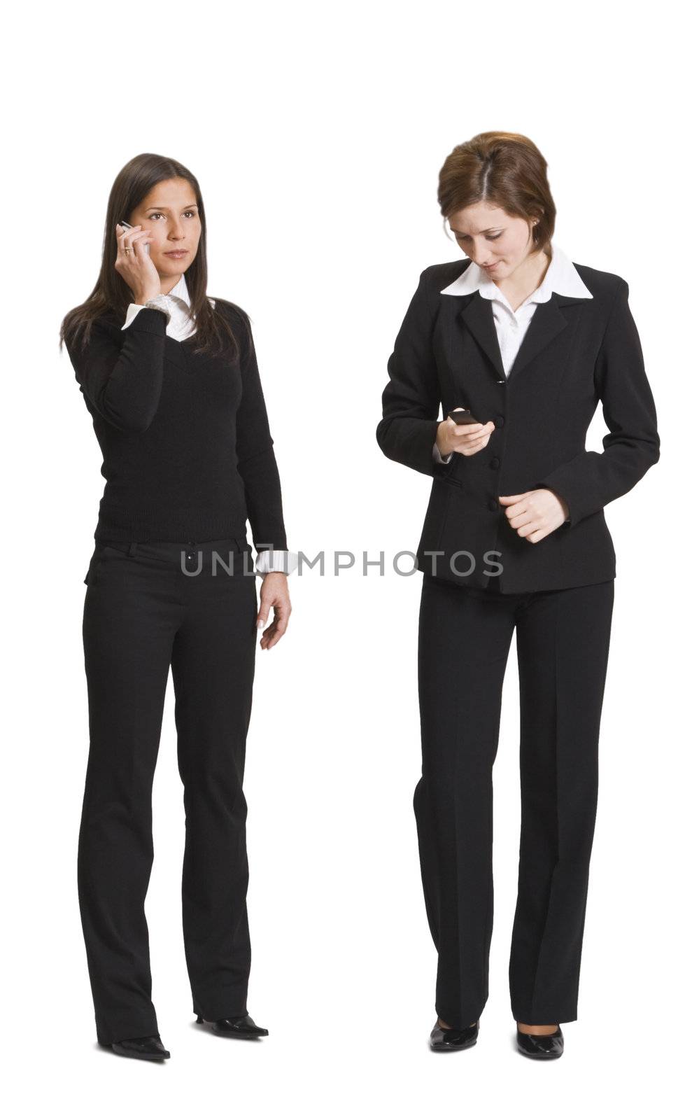 Two businesswomen using mobile phones isolated against a white background.