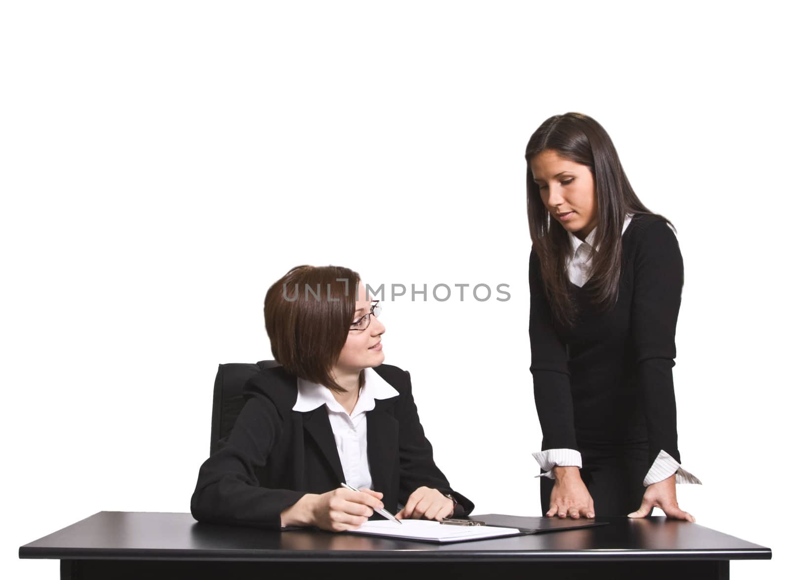 Two businesswomen discussing a file in the office.