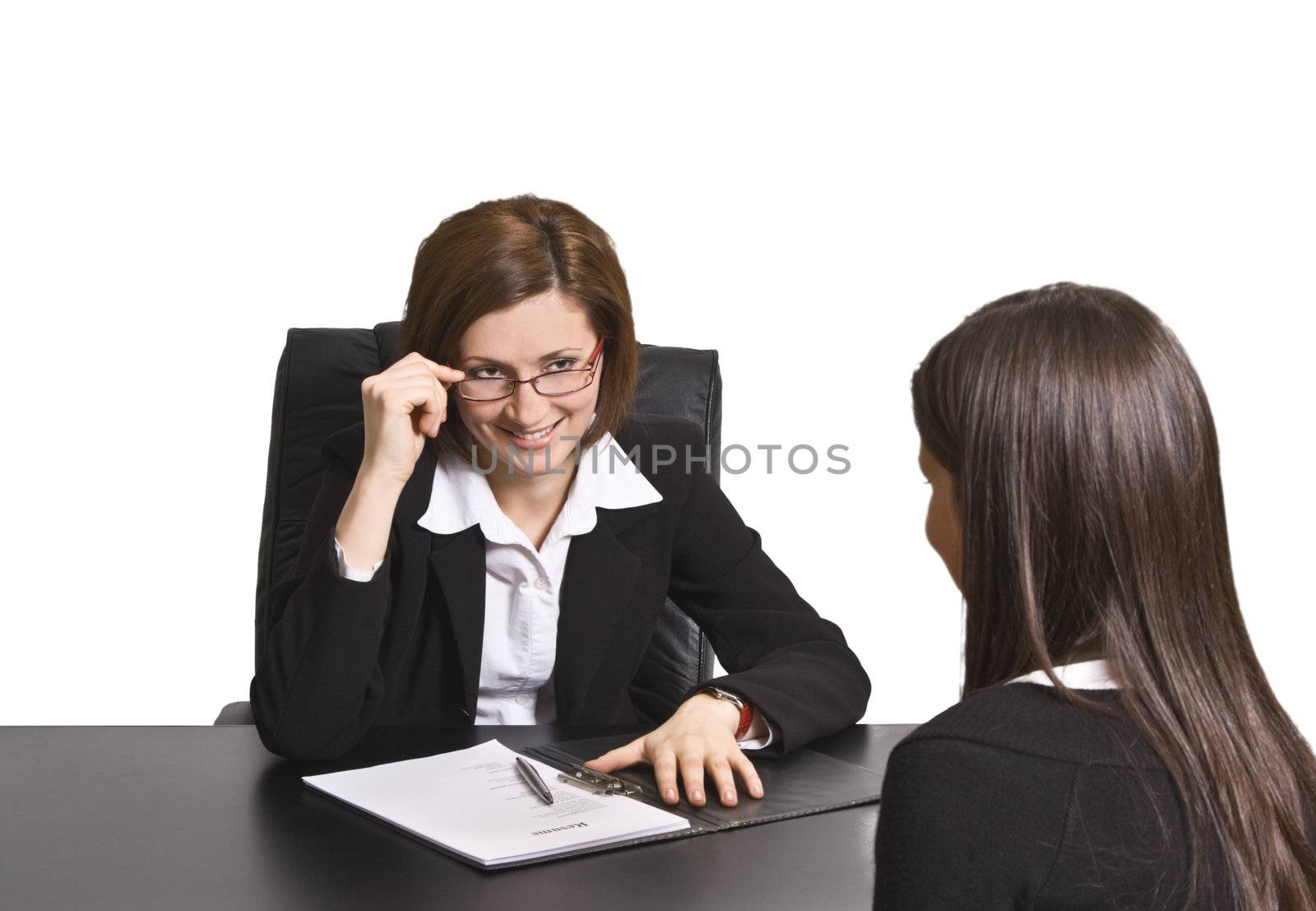 Two businesswomen having fun at an interview in the office.The documents on the desk are mine.