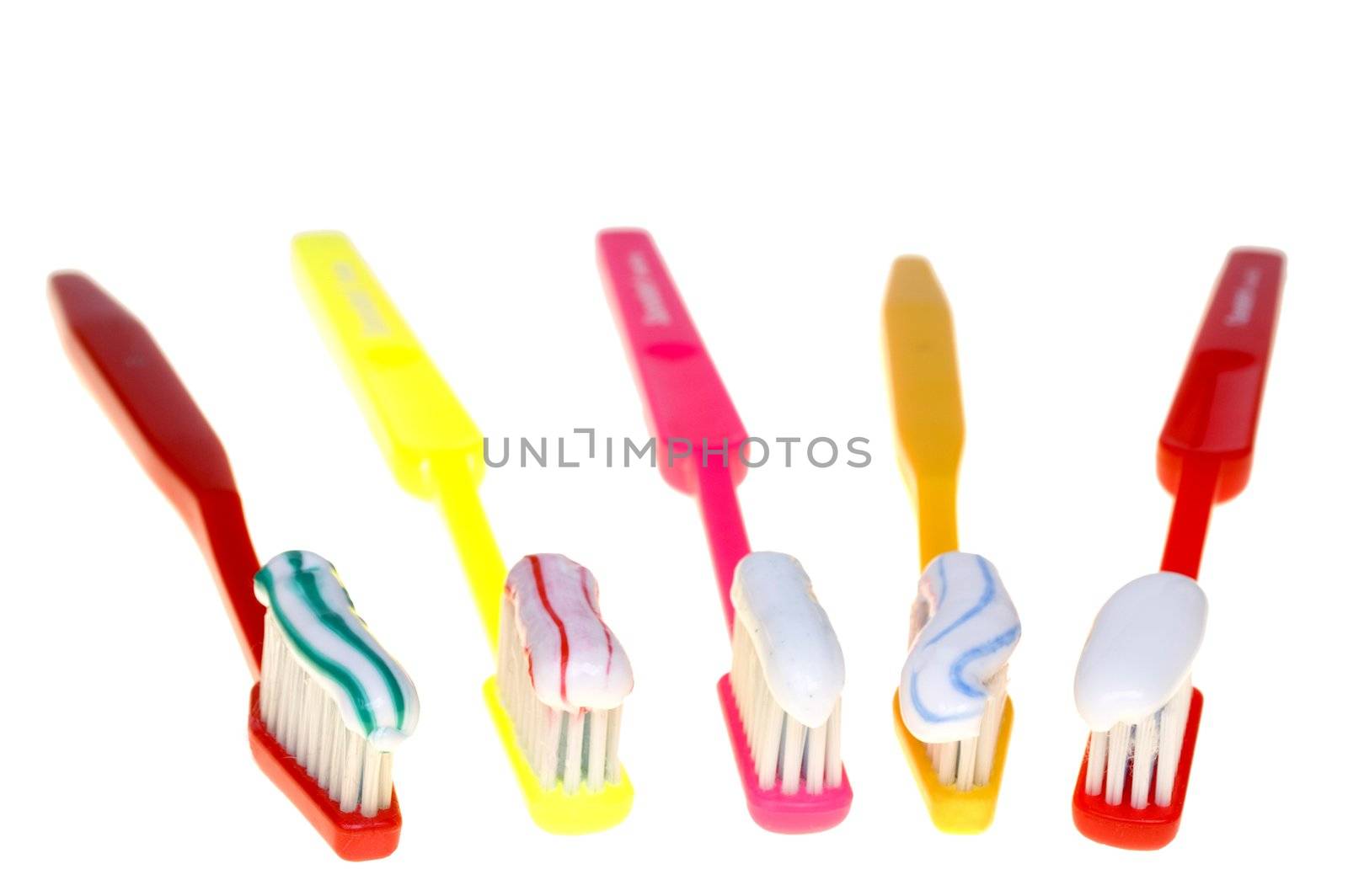 Colorful brushes with color tothpaste isolated on white background