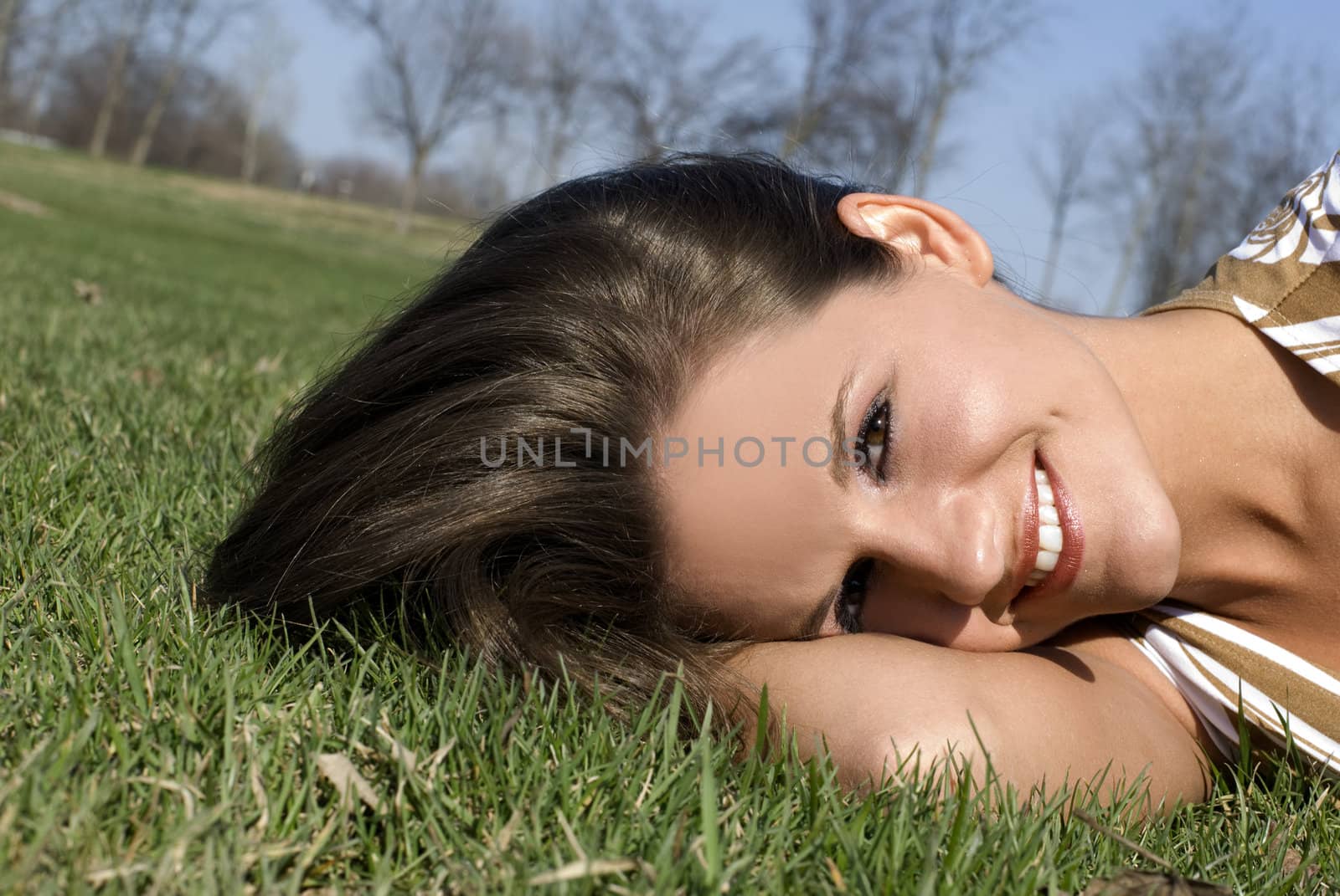 A beautiful and cute model laying on the grass.