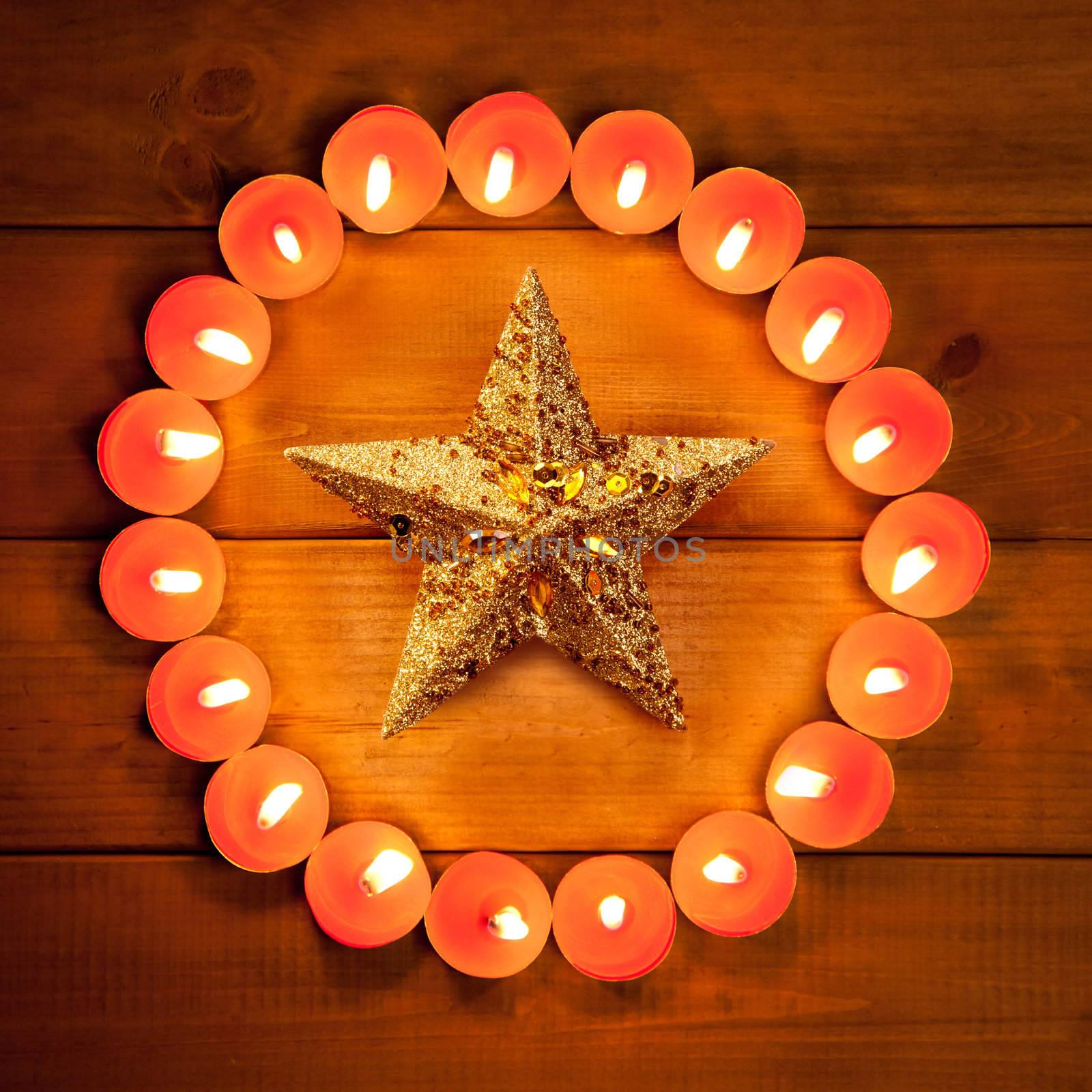 christmas candles circle over wood and golden star symbol