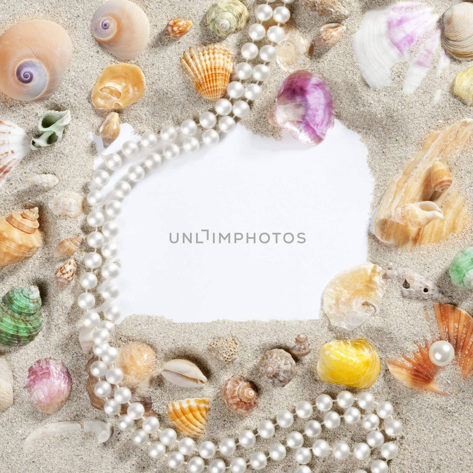 frame composition over beach sand beach with blank paper with pearls and shells