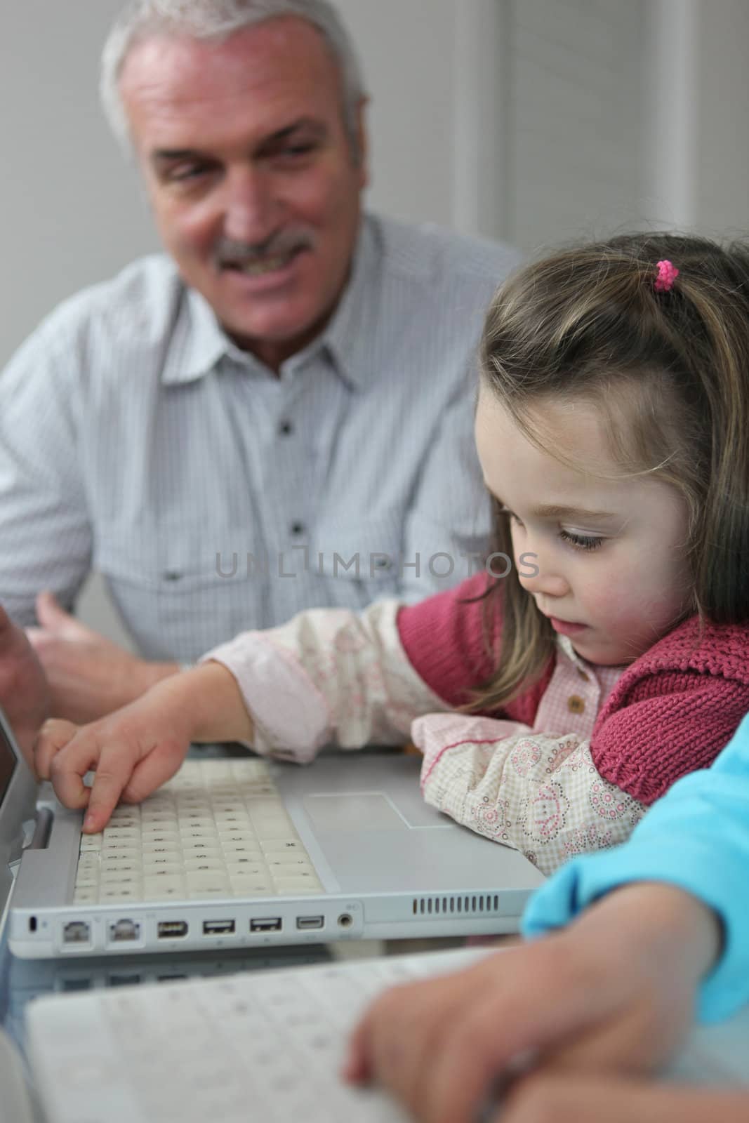 Child on a laptop with her grandfather