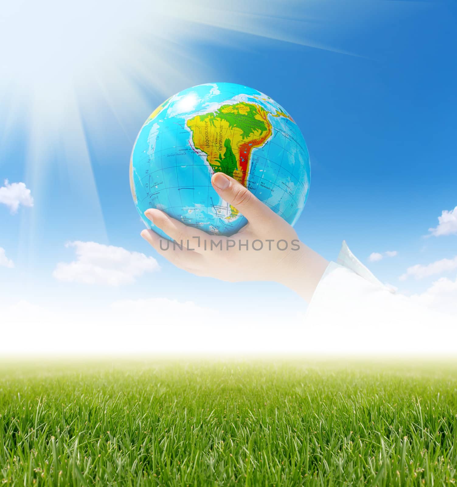 globe in hands under blue sky by rudchenko