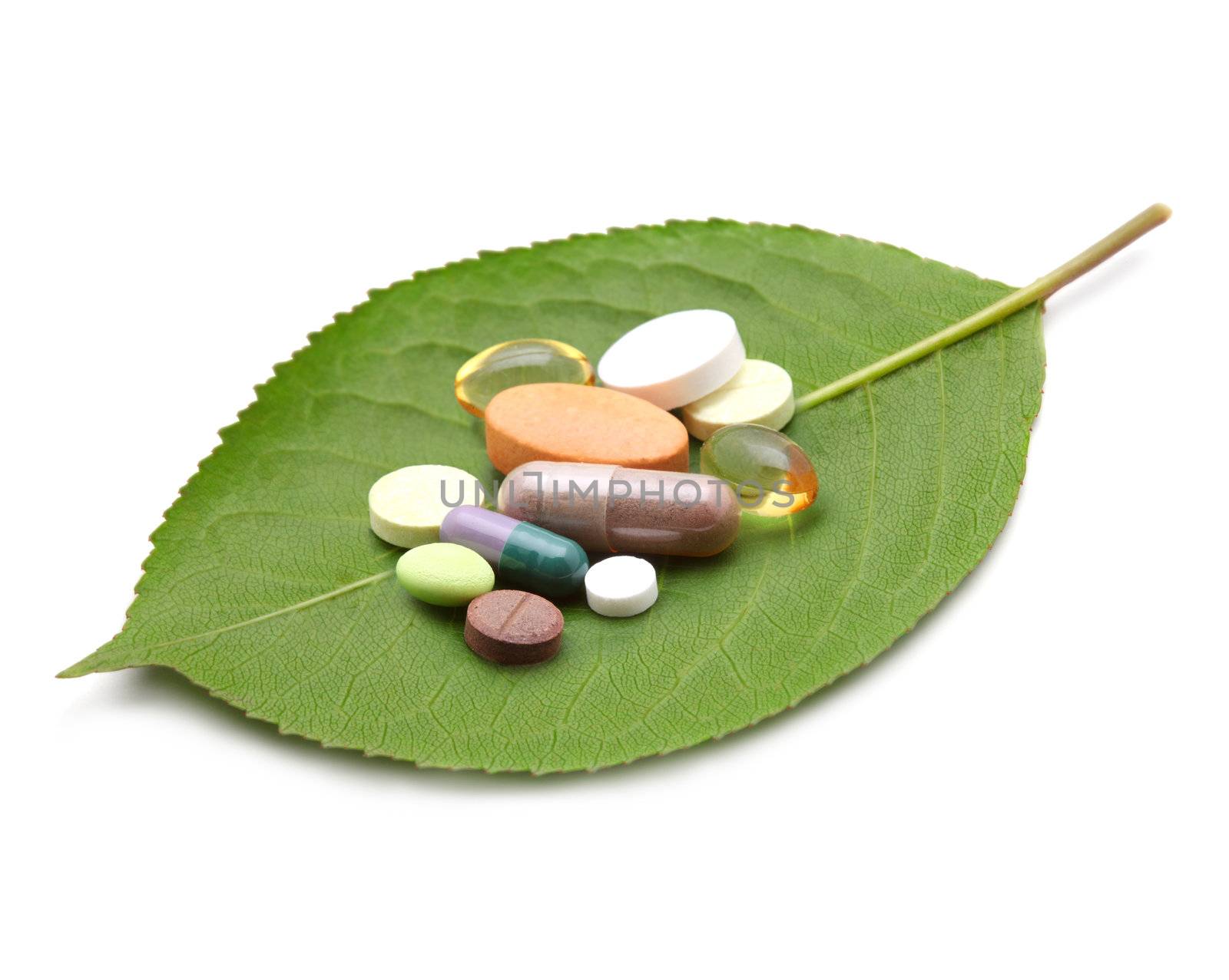 vitamins, tablets and pills on green leaf by rudchenko