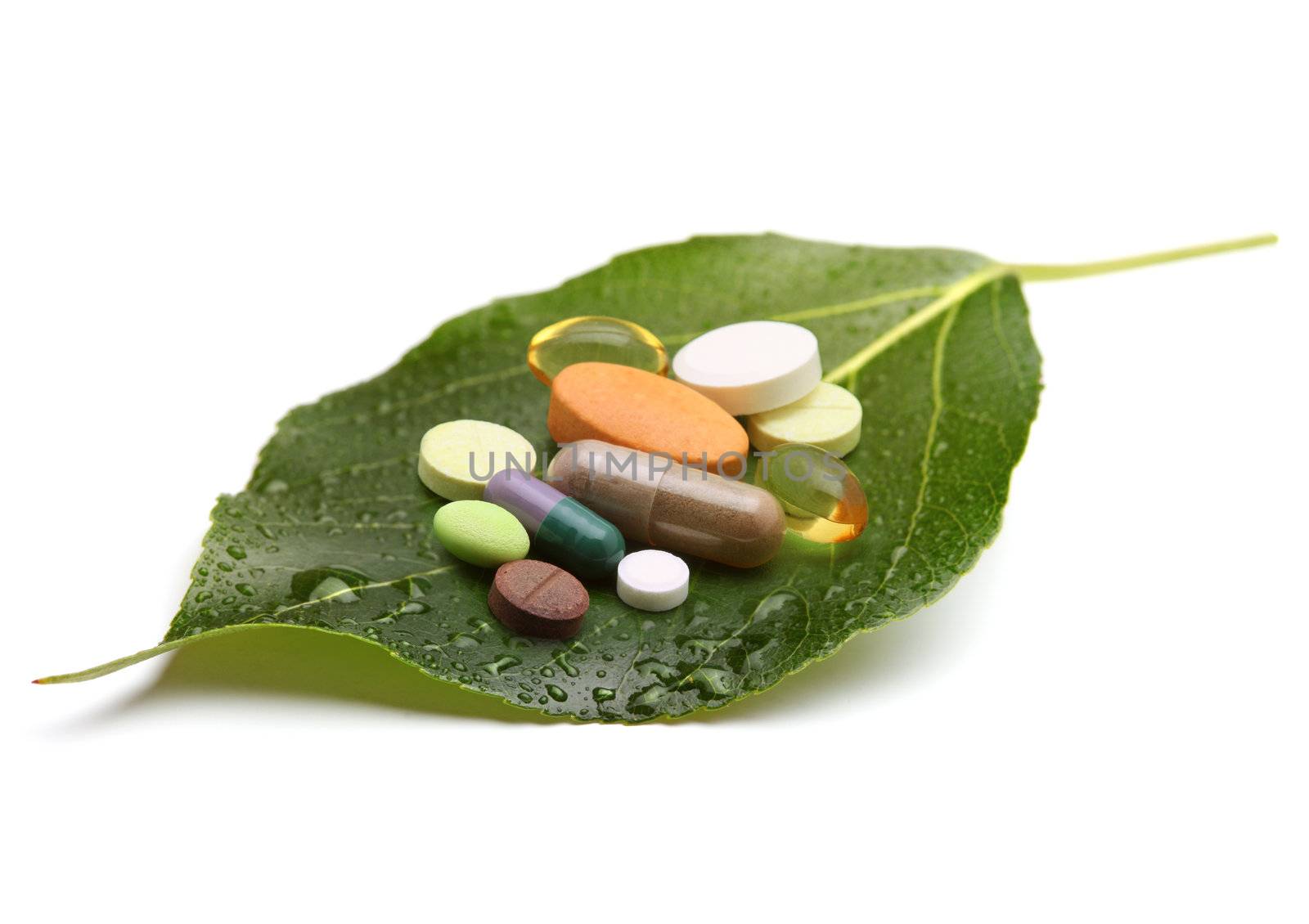 vitamins, tablets and pills on green leaf by rudchenko