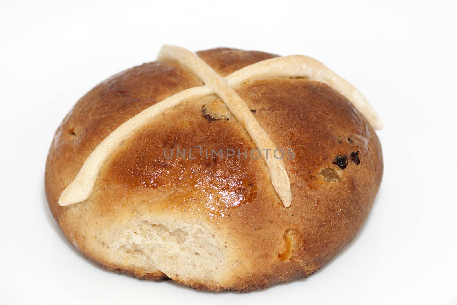 Cross bun with raisins and dried apricots isolated on white